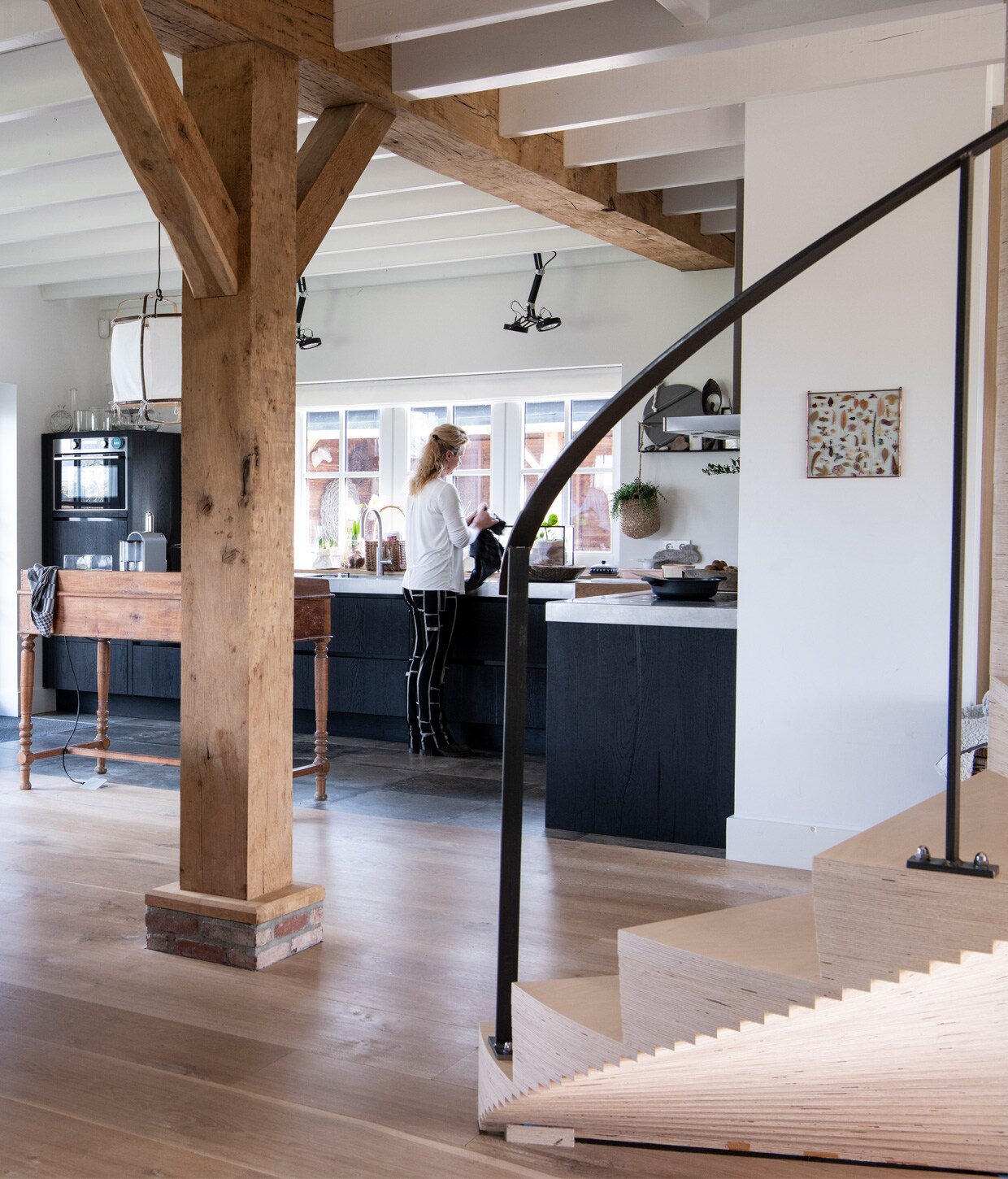 Licht eiken plankenvloer in drie breedtes Dennebos Flooring, trap ontworpen door Buro Logge in samenwerking met Westenwolf Trappen. Balkenconstructie oude onbehandelde eiken balken Frank Pouwer, vazen Tica, verf op de muur Persian Grey van Painting the Past. Oude houten commode is privébezit.