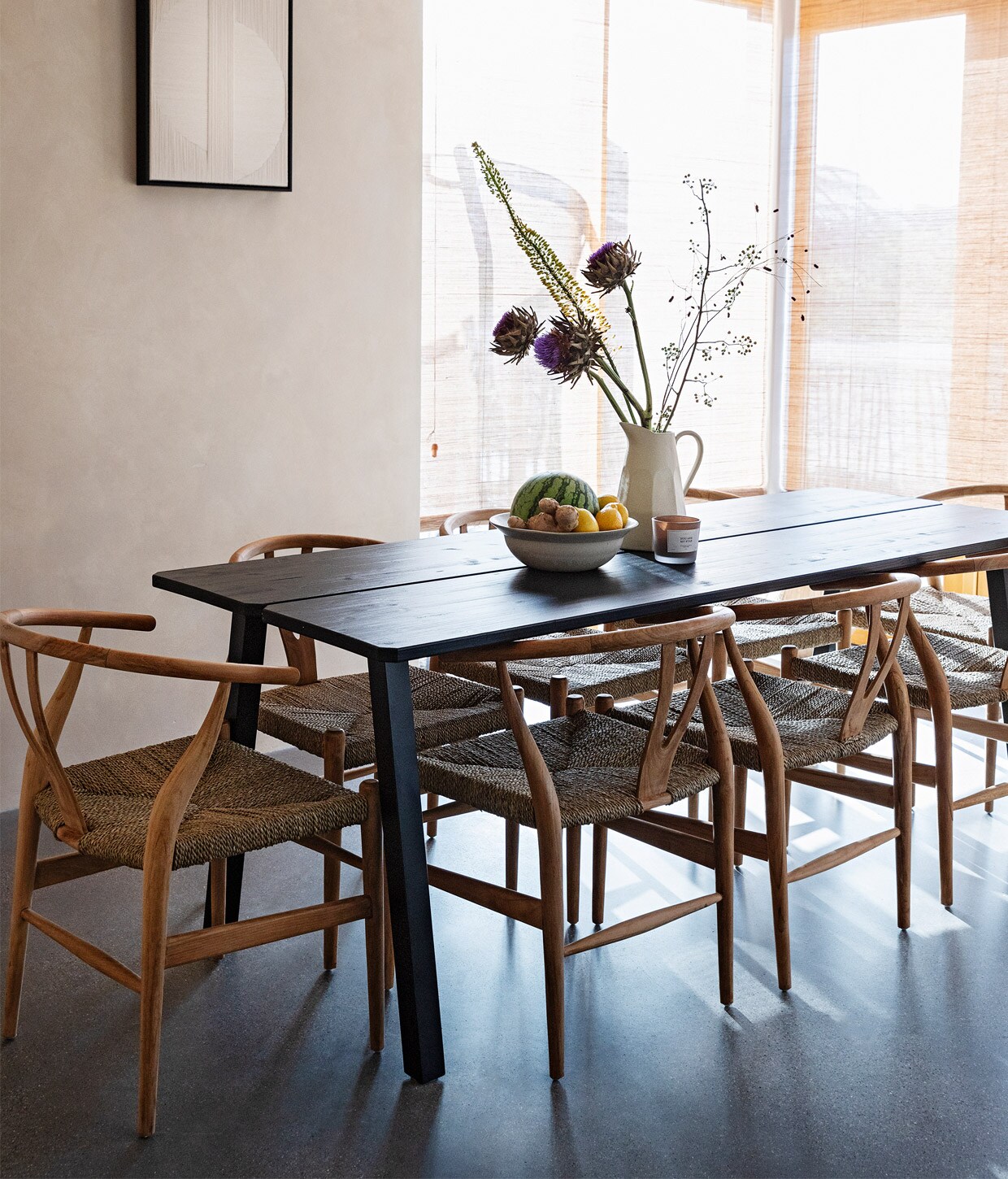 Kalkverf Mykonos van Bauwerk Colour, plafondlampen Serax, kunst aan muur Alyssa Breid via Studio Yen. Eettafel Triomf van Woood, stoelen Christiaensen &amp; Christiaensen, schaal en kan Zara Home, geurkaars L’Aimé. Raambekleding Japanese Blinds via Atelier ND Interior.