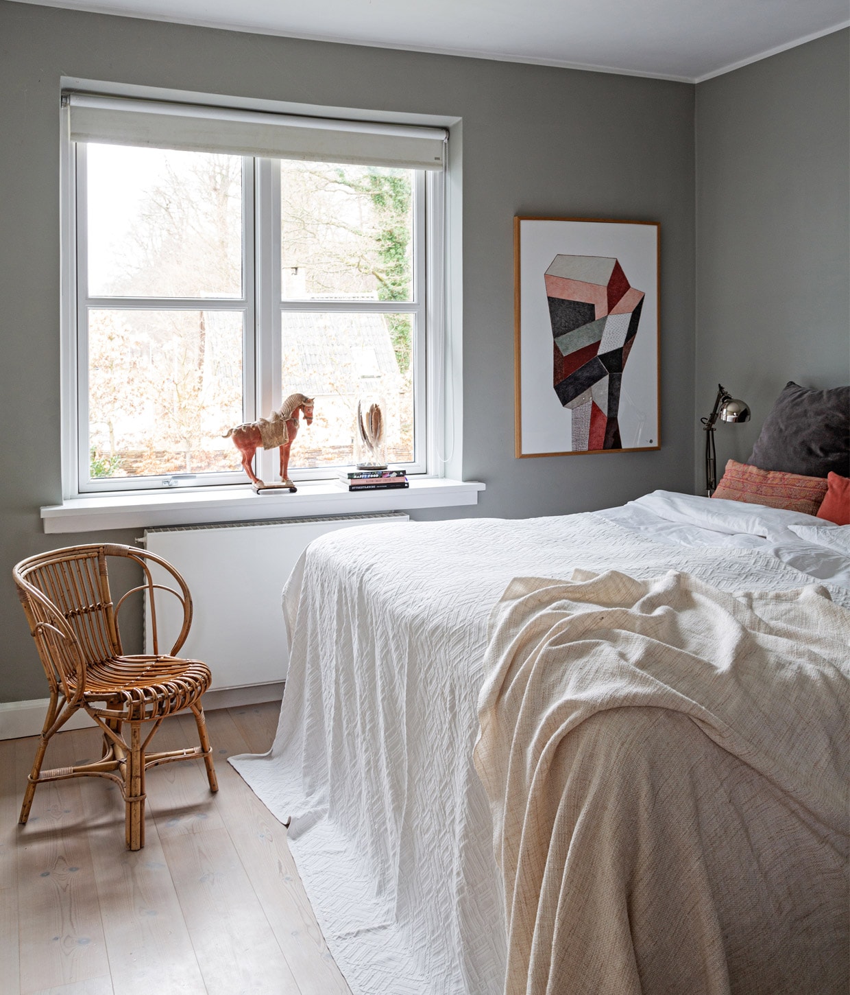 Muurverf Lamp Room Grey van Farrow &amp; Ball. Kunstwerk Nathalie du Pasquir. Houten paard en gevlochten stoel erfstukken. Kussens Studio Oliver Gustav en The Travelling Band. Lakens Ilva. Nachtlamp Ikea.