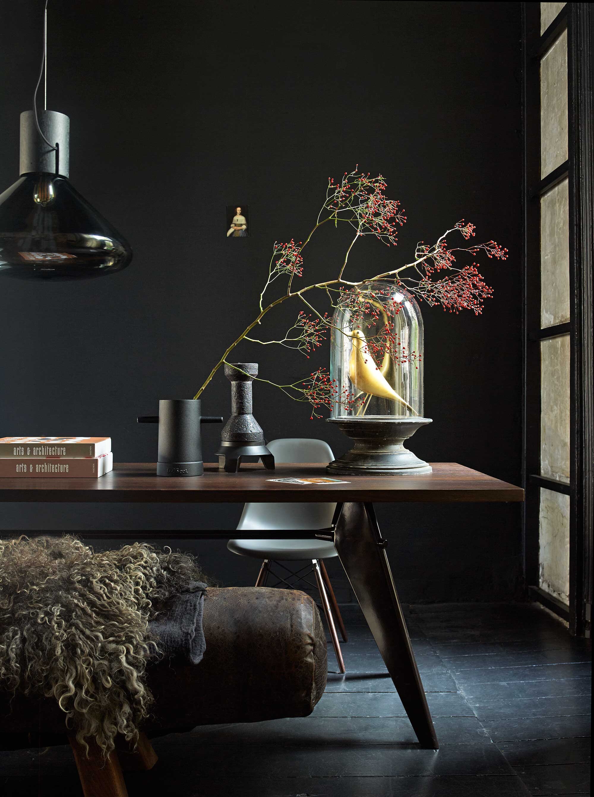 Muurverf Off Black uit de vtwonen collectie (Karwei). Ansichtkaart (Art Unlimited). Paard als bank, verkrijgbaar in verschillende afmetingen (Brût Amsterdam). Schapenvacht op vilt (l’Authentique). Tafel van Prouvé, Eames kuipstoel, Shadow hanglamp van Brokis, Ø 54 cm (Mobilia). Vaasobject (Functionals). Kaarsenstandaard en kaars van Jeroen Wand in samenwerking met Cor Unum (Studio Jeroen Wand). Stolp op voet, hoogte 64 cm (Hoffz). Gouden vogel en boeken privébezit.
