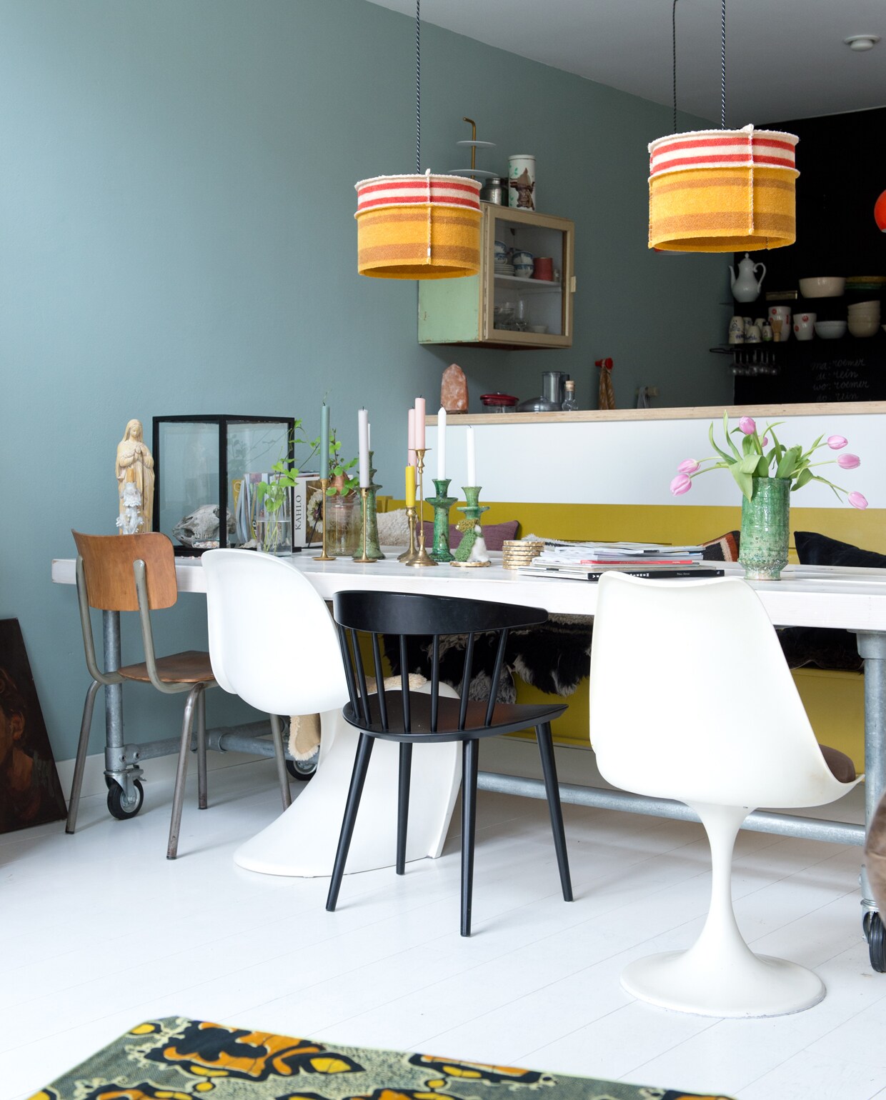 De bank hebben Jet en Michiel op maat laten maken bij oudisnieuw.net. Zwarte eetkamerstoel Hay. Tulip Chair van Eero Saarinen en witte Panton Chair via Marktplaats.
