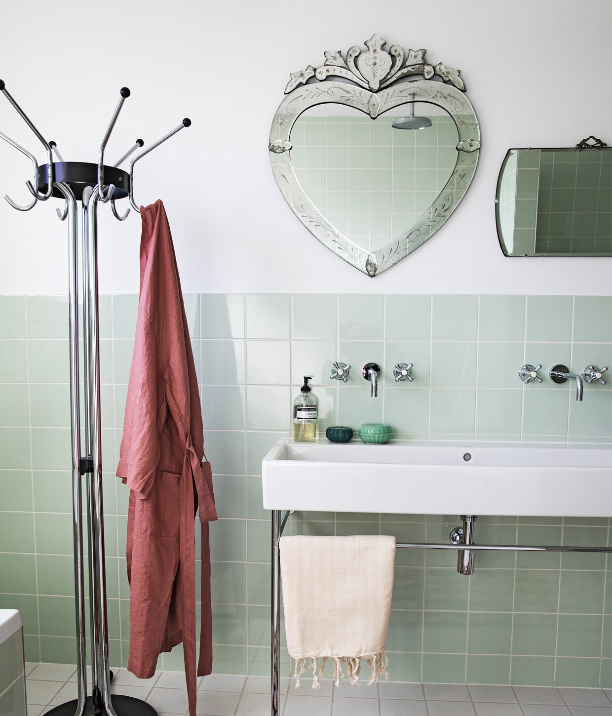 Groene tegels Mosa via Kol Tegels, Venetiaanse spiegel hartvormig Sissy-Boy, spiegel rechthoekig antiek, kranen onbekend, wastafel Duravit, kapstok Tubax vintage, badjas, hamamdoek en vloerkleed The Souks, groene bakjes Ikea, zeep Marie-Stella-Maris.