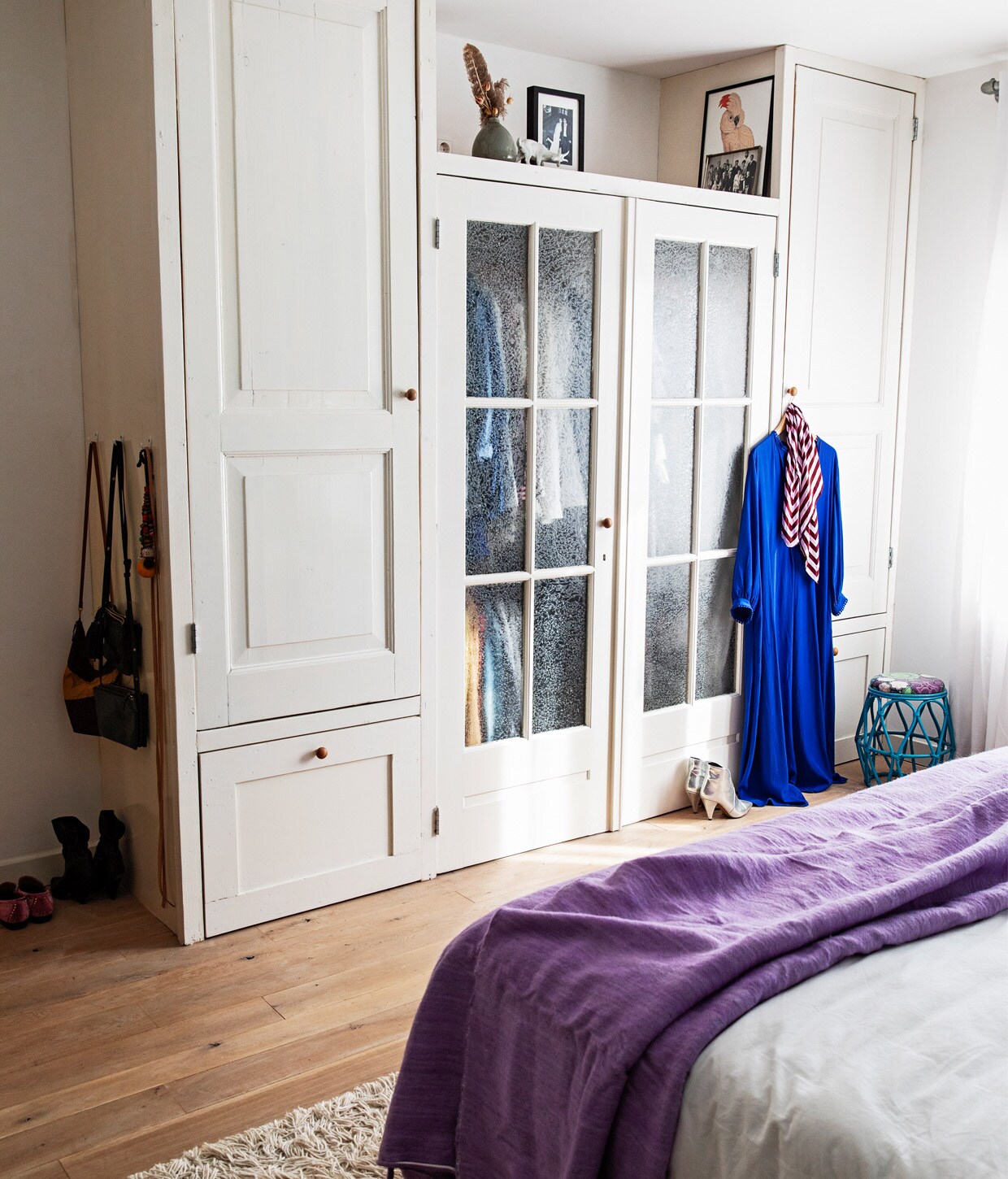 Kast gemaakt met oude deuren uit huis en deuren van Burbri, verf op kast zijdeglans Ral 9010, fotolijsten onbekend, vaas cadeau gekregen, lichtdoorlatende gordijnen vtwonen, blauw krukje vintage, handgemaakte berber pompomdeken The Souks, wit beddengoed Four Leaves, vloerkleed Ikea.