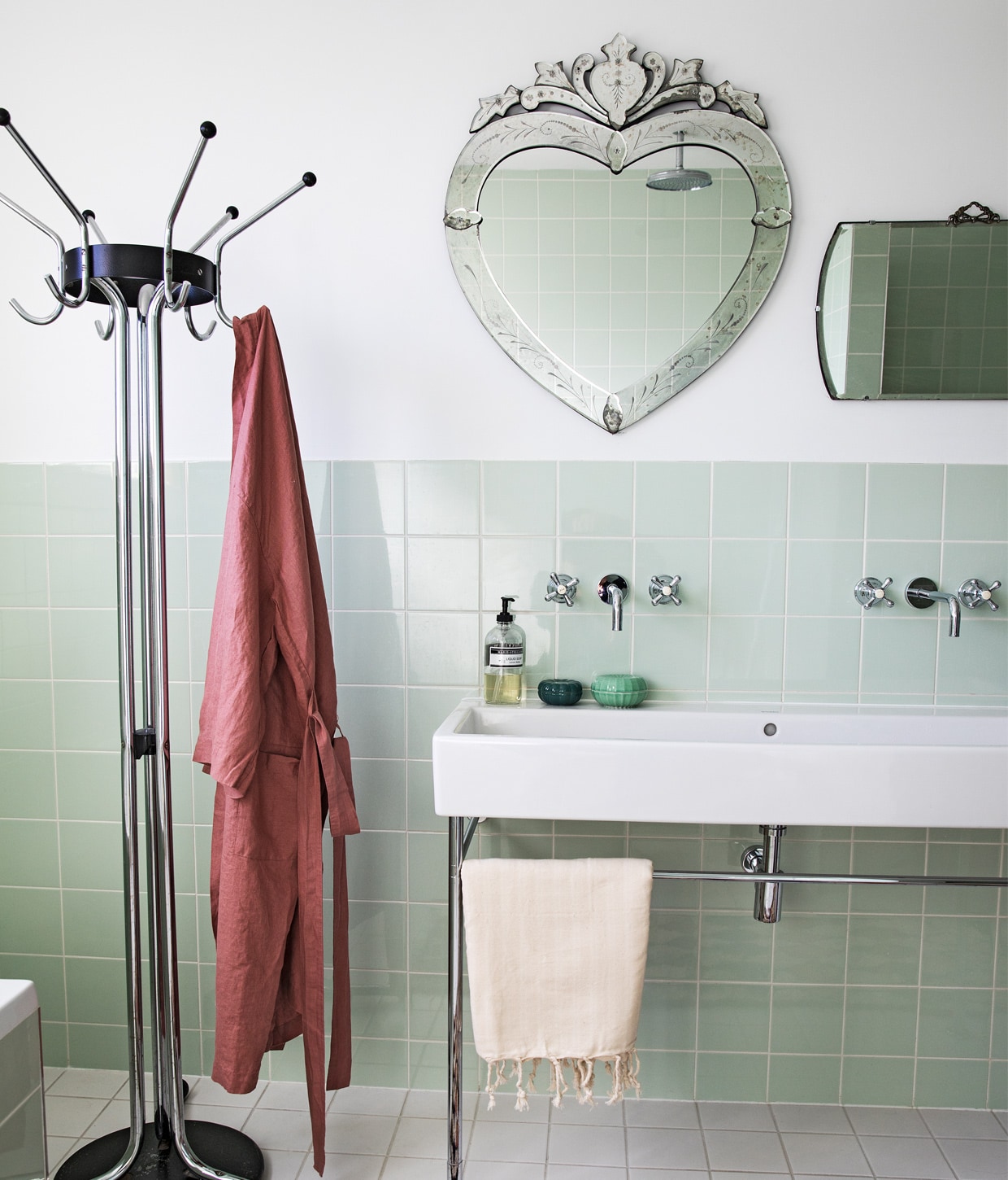 Groene tegels Mosa via Kol Tegels, Venetiaanse spiegel hartvormig Sissy-Boy, spiegel rechthoekig antiek, kranen onbekend, wastafel Duravit, kapstok Tubax vintage, badjas, hamamdoek en vloerkleed The Souks, groene bakjes Ikea, zeep Marie-Stella-Maris.