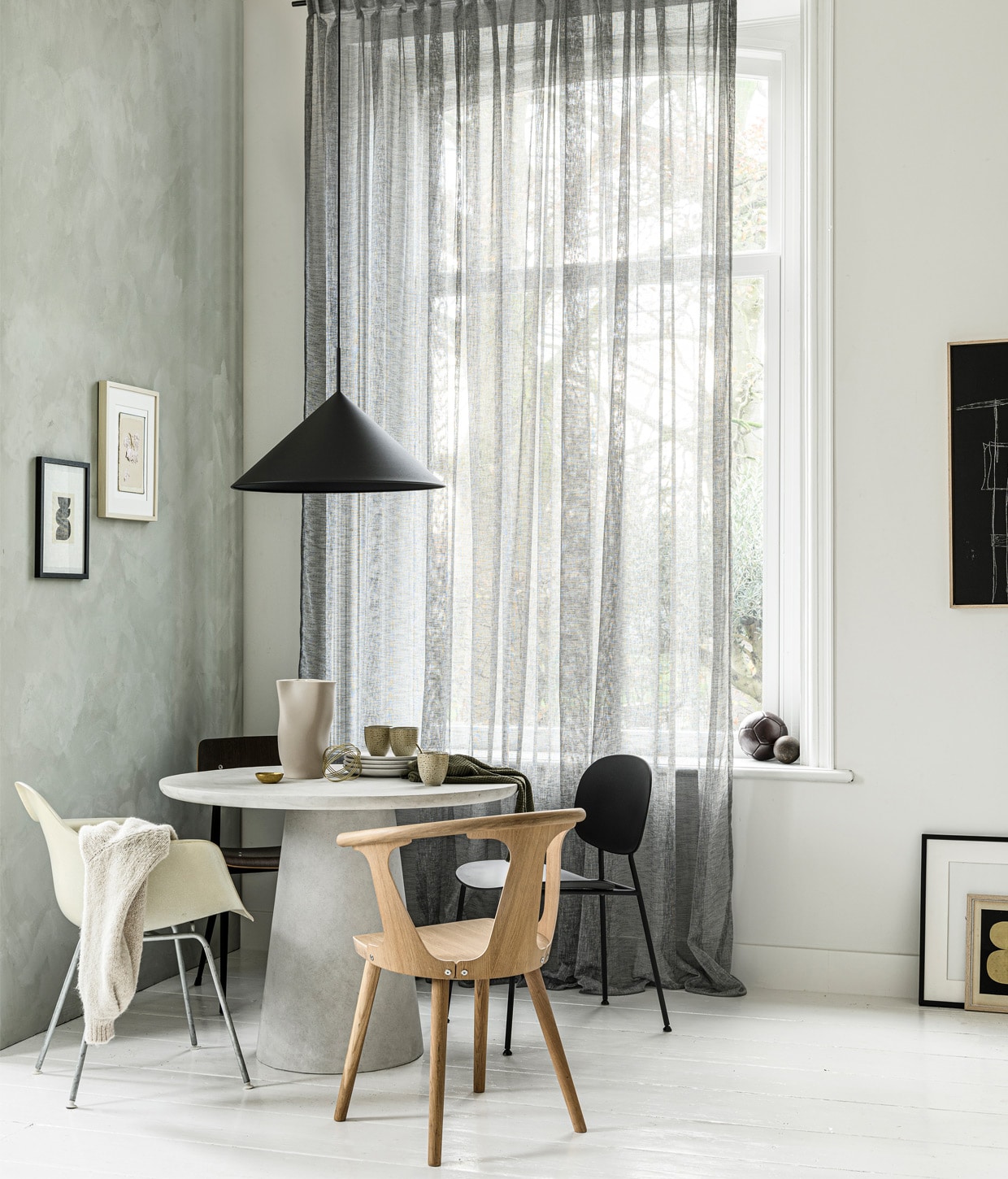 Gordijn op maat in stof Weave kleur 2712, per meter € 27,99. M.m.v. basiclabel.nl (betonlook tafel Damon), demachinekamer.nl (Eames-stoel), loods5.nl (stoel In Between van &amp;Tradition, zwarte stoel rechts van Menu, zwarte stoel links Result van Hay), hkliving.nl (lamp, mokken, zwart kunstwerk), EawyArt via etsy.nl (kunstwerk in zwarte lijst), wonderwallstudios.com (kunstwerk in lichte lijst), hm.com (theedoek), vestingh.nl (kalkverf Smoking Glass). Overig privébezit.