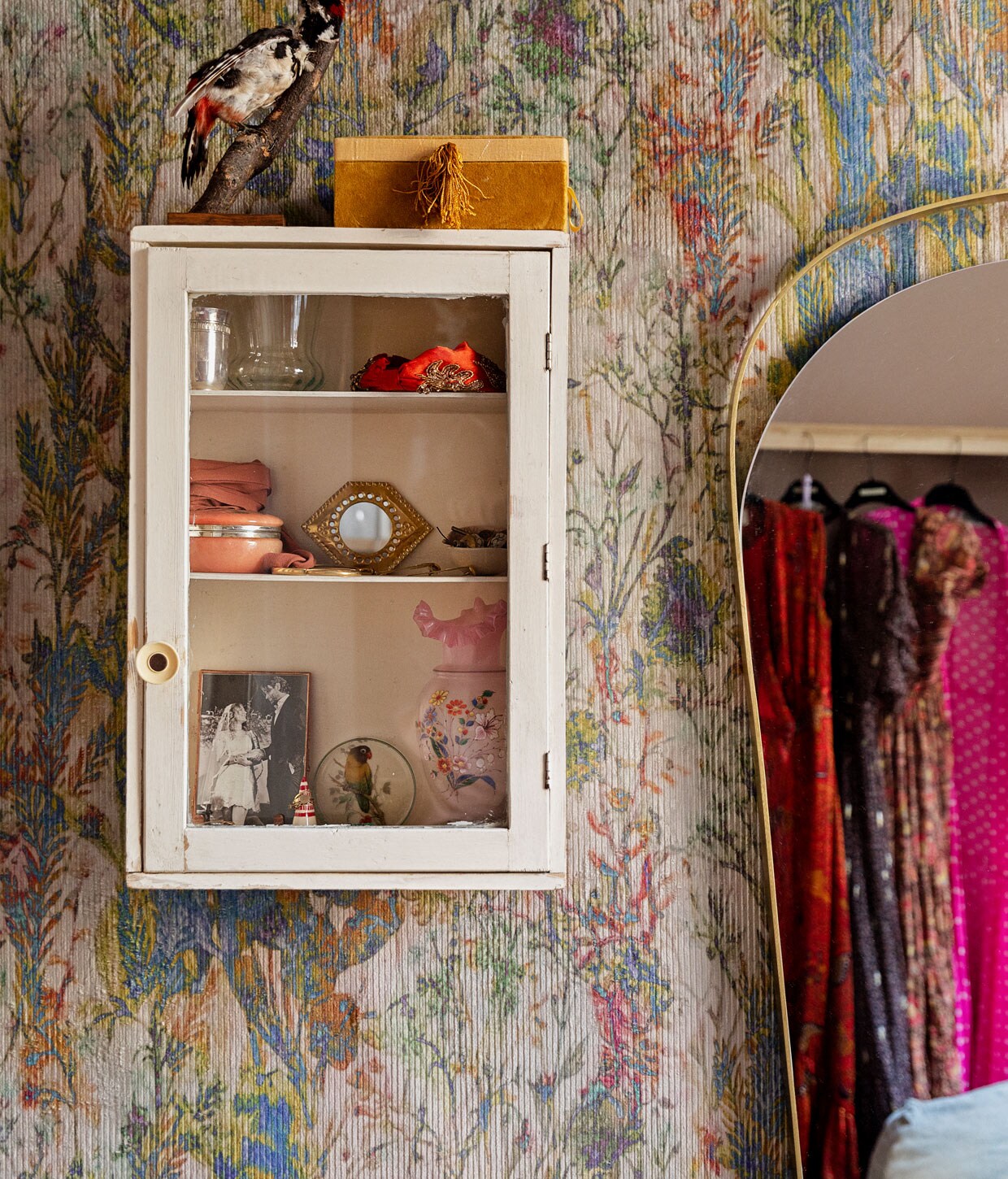 Behang Arte Walls, wandkast waarschijnlijk via Van Dijk &amp; Ko, spiegel Westwing. Items in kastje: trouwfoto in een messing lijstje van De Weldaad, zilveren geboortebeker van Vito, roze sieradendoosje van keramiek cadeau gekregen, oranje haarband van Antropologie, doosje op het kastje A La, vogeltje van een rommelmarkt.