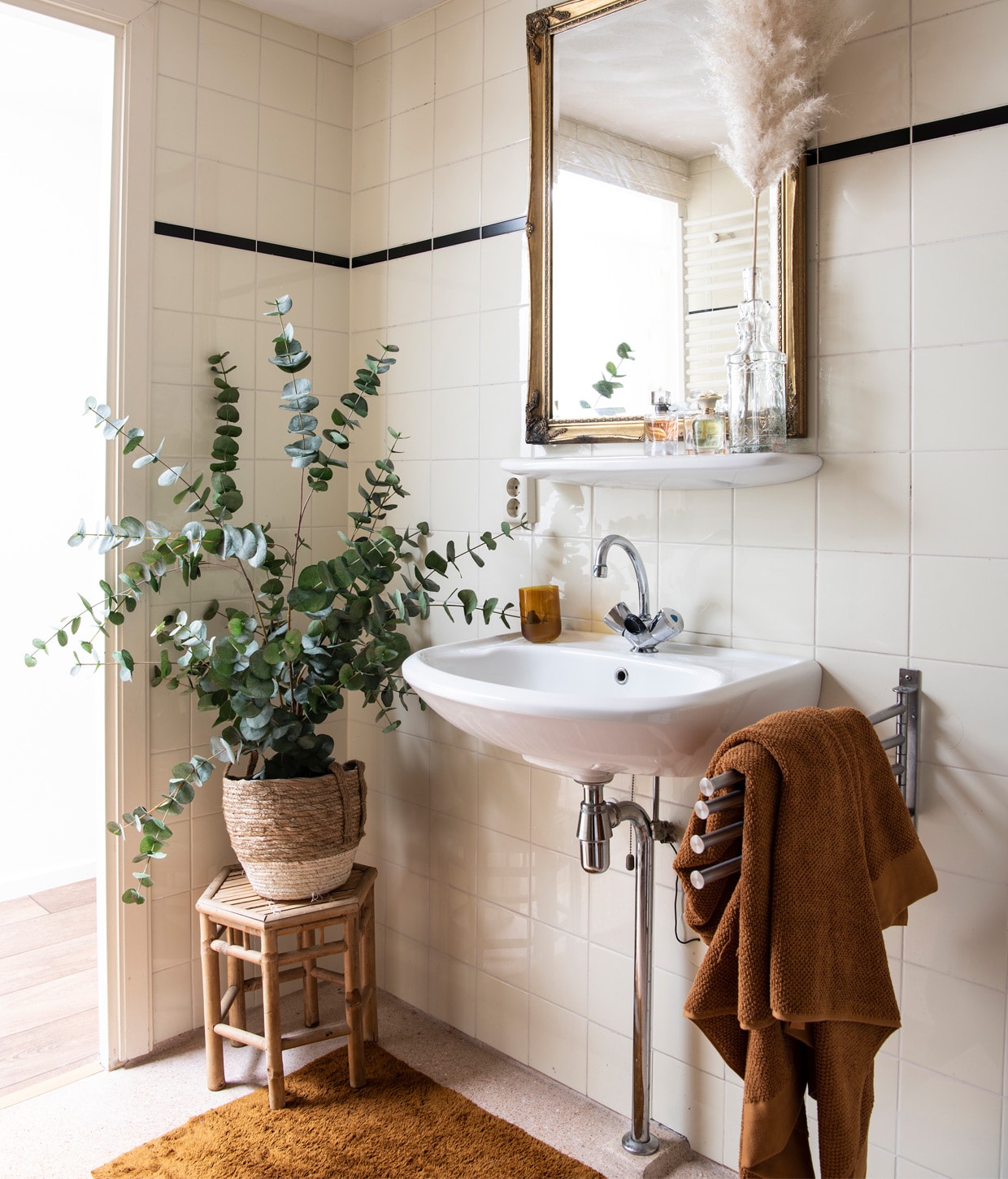 Plafondlamp BePureHome. Terracotta kleed, glas en handdoek Zara Home. Kruk, pot en eucalyptuskunstplant Blooming Interior. Spiegel van Evy’s ouders. Herkomst overige onbekend.