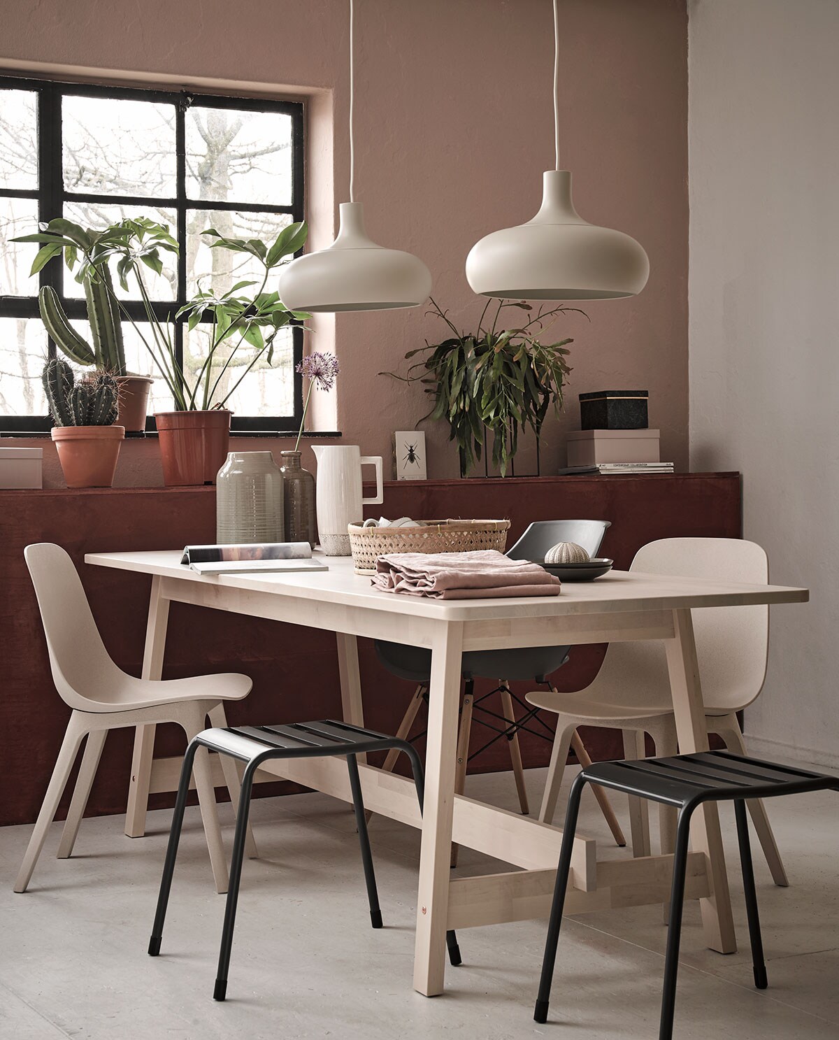 Op de wand kleur Skin Powder, lambrisering in Cardinal Red matte krijtverf (Pure &amp; Original). Eettafel Norraker, stoelen Odger, lampen Vaxjo (Ikea). Metalen kruk Napels per stuk, wandrekje gebruikt als plantenstandaard, roze opbergdoos, groene opbergdoos, vaas links, bruine vaas, klein vaasje (Kwantum). Grijze eetkamerstoel, kan (Trendhopper). Mand (Loods 5). Ontbijtbordjes grijs (Xenos). Tafelkleed van gewassen linnen (H&amp;M Home). Overig privébezit.