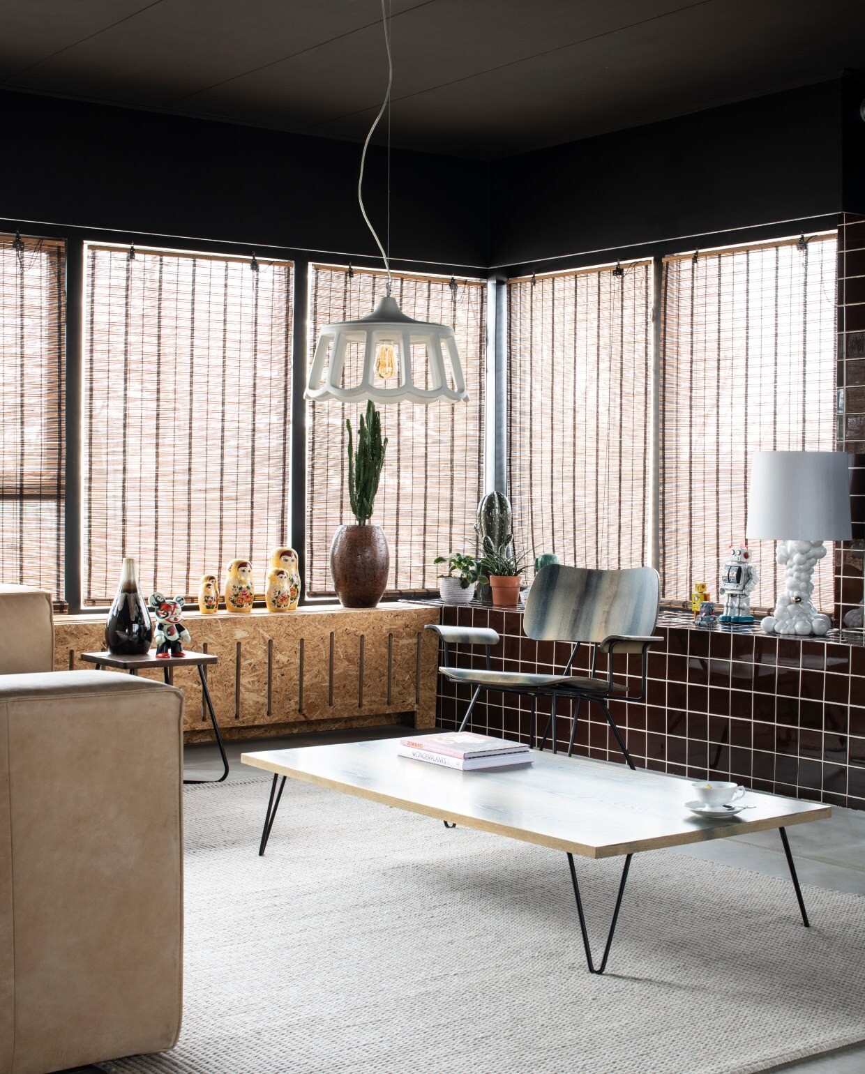 Grijs kleed vtwonen. Leren bank Marktplaats. Salontafel en stoel Diesel living. Witte tafellamp Bubbles van Jaime Hayon. Hanglamp Le Pupette van Karman via Slowclub. Raambekleding Xenos. Bijzettafels Kwantum. Bruine vaas Intratuin. De bruine tegels kocht Marike als partij via Marktplaats.