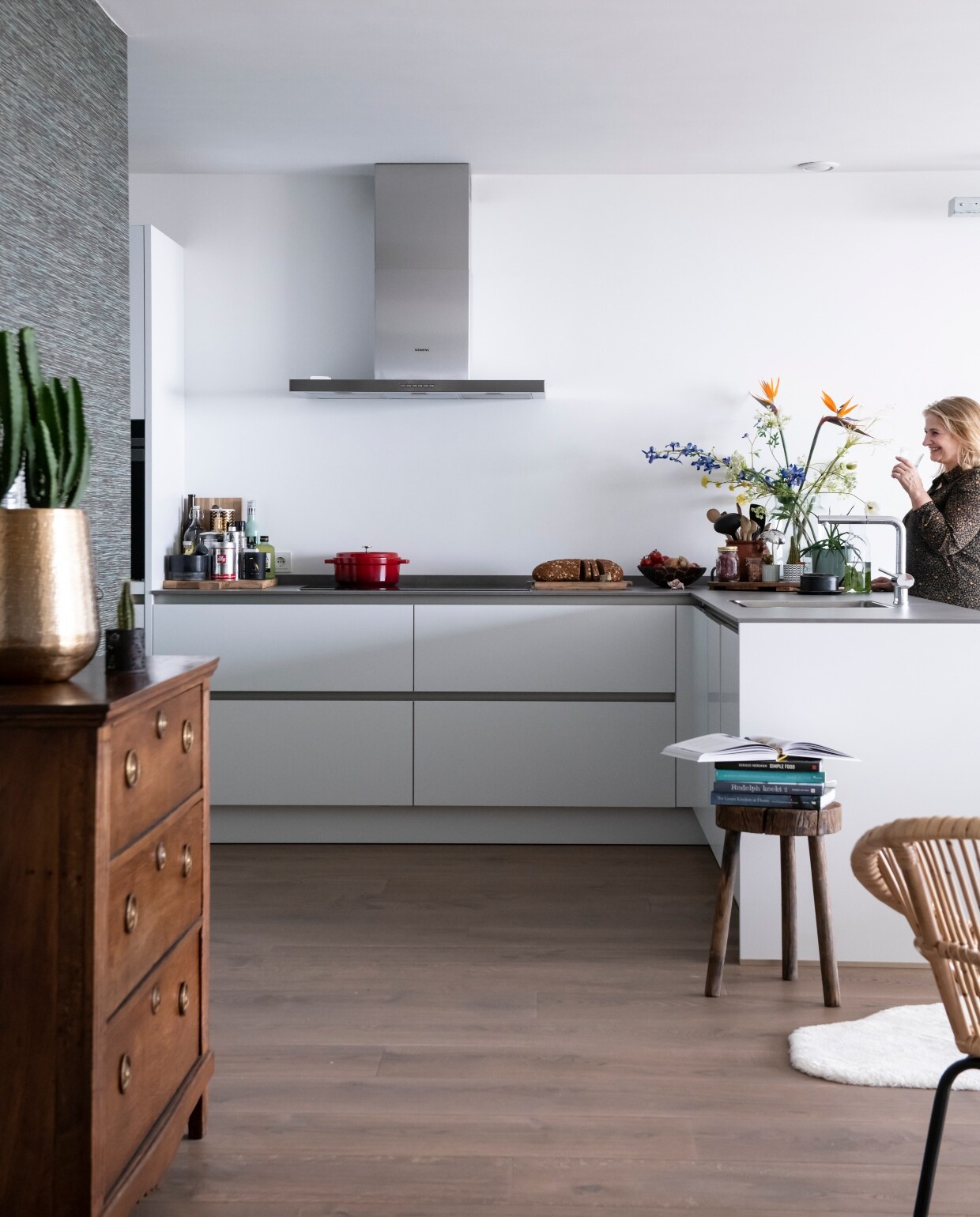 Door het hele appartement ligt een eikenhouten vloer van Martijn de Wit Vloeren. Keuken Ekelhoff Küchen in Duitsland. Kruk via groothandel Tica. De ladekast is een erfstuk. Goud- kleurige bloempot Intratuin. Behang Anthology I Seri Slate via De Mooiste Muren.