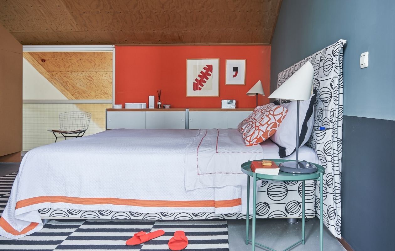 Bed Vispring, bekleed met stof van Ikea. Kussens Zara Home. Tafeltje en vloerkleed Ikea, tafellampen Sirrah. Muurkunst van El Gato en een onbekende kunstenaar (de komma). Kasten Kewlox.