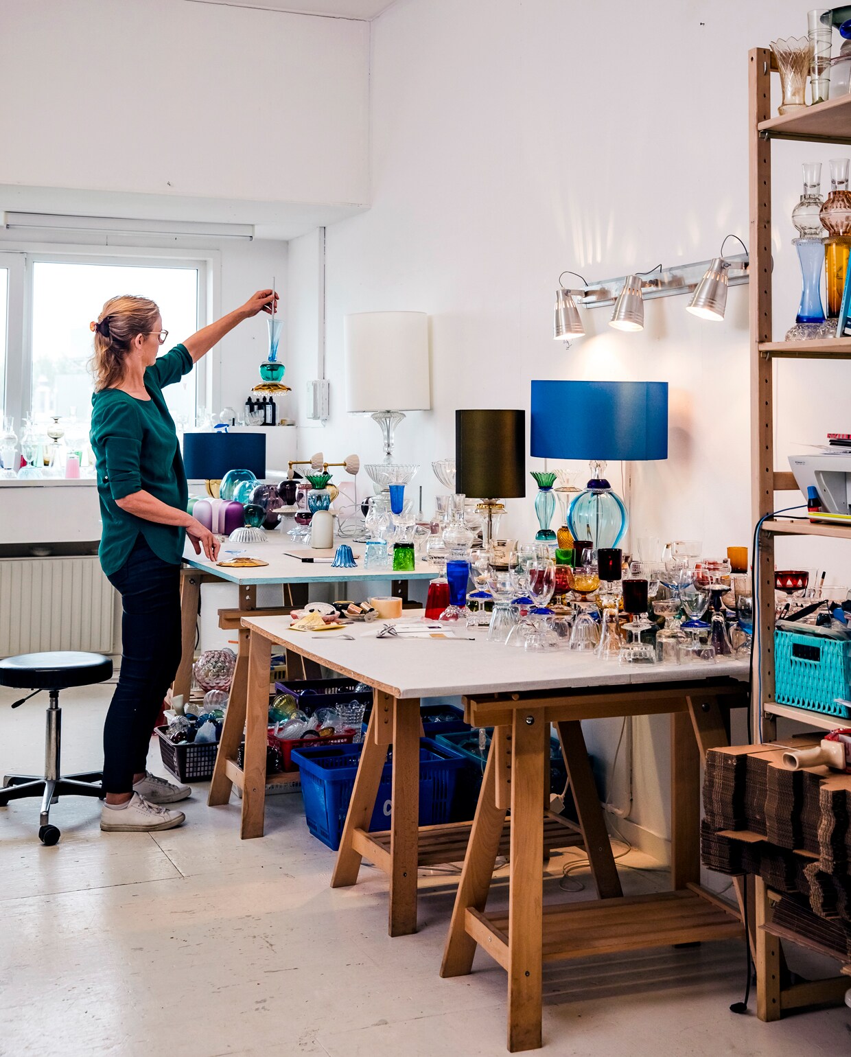 De tafel in het hoekje bij het raam is ‘niet de poppenhoek, maar de plakhoek’. Hier plakt Roos de glazen onderdelen voor de glazen en kandelaars aan elkaar met uv-lijm en een uv-lamp. ‘Ik kan het ook op de vensterbank in de zon laten uitharden, maar dat duurt me te lang.’