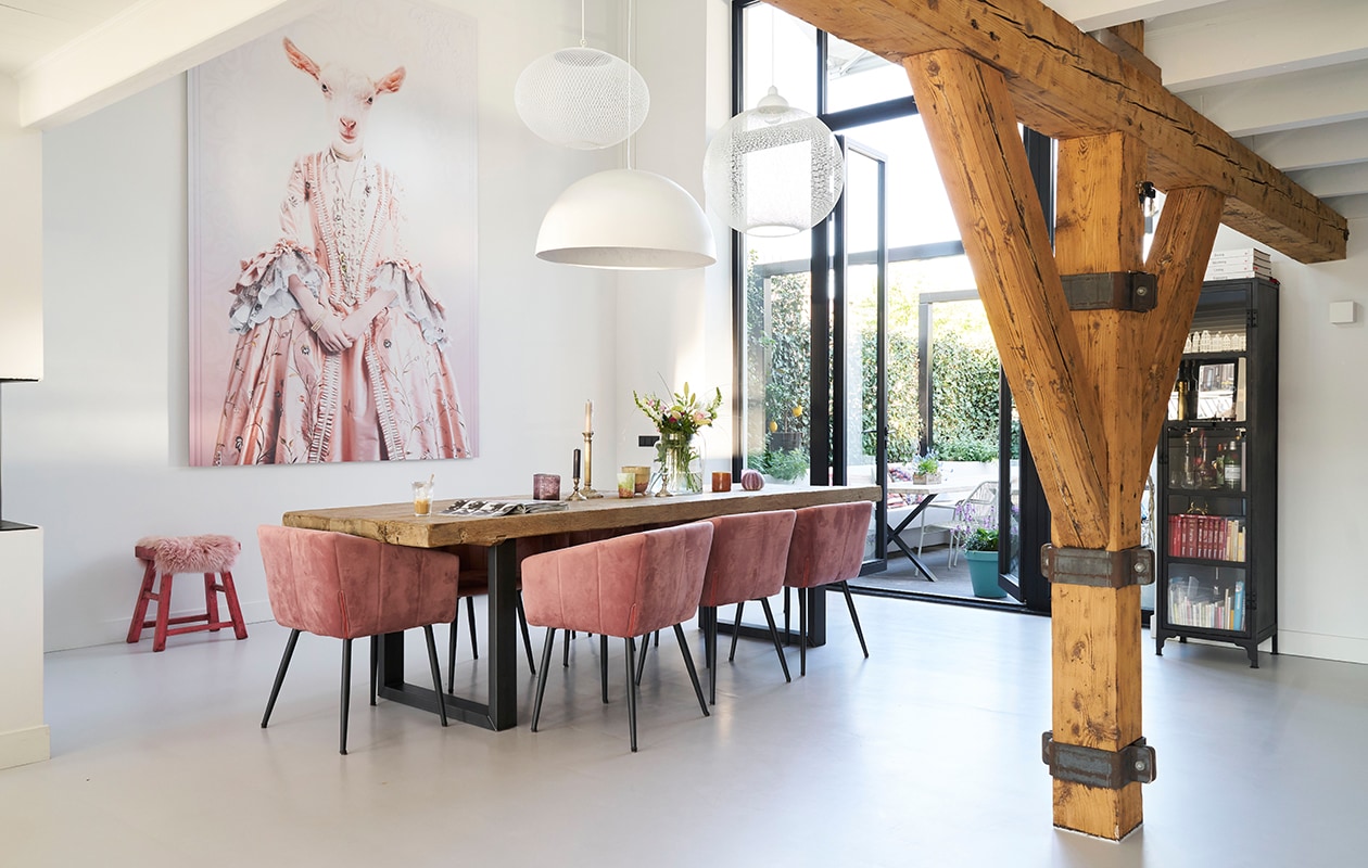 Eettafel eigen ontwerp en op maat gemaakt. Fluwelen stoelen Liv van Kick. Lampen (v.l.n.r.): NR2 van Moooi, Sky Garden van Flos, Non Random van Moooi. Fotocollage Mondi Art Shop. Kruk De Pagter Interieurs. Vintage kandelaars, keramiek en glaswerk in de loop der jaren verzameld.