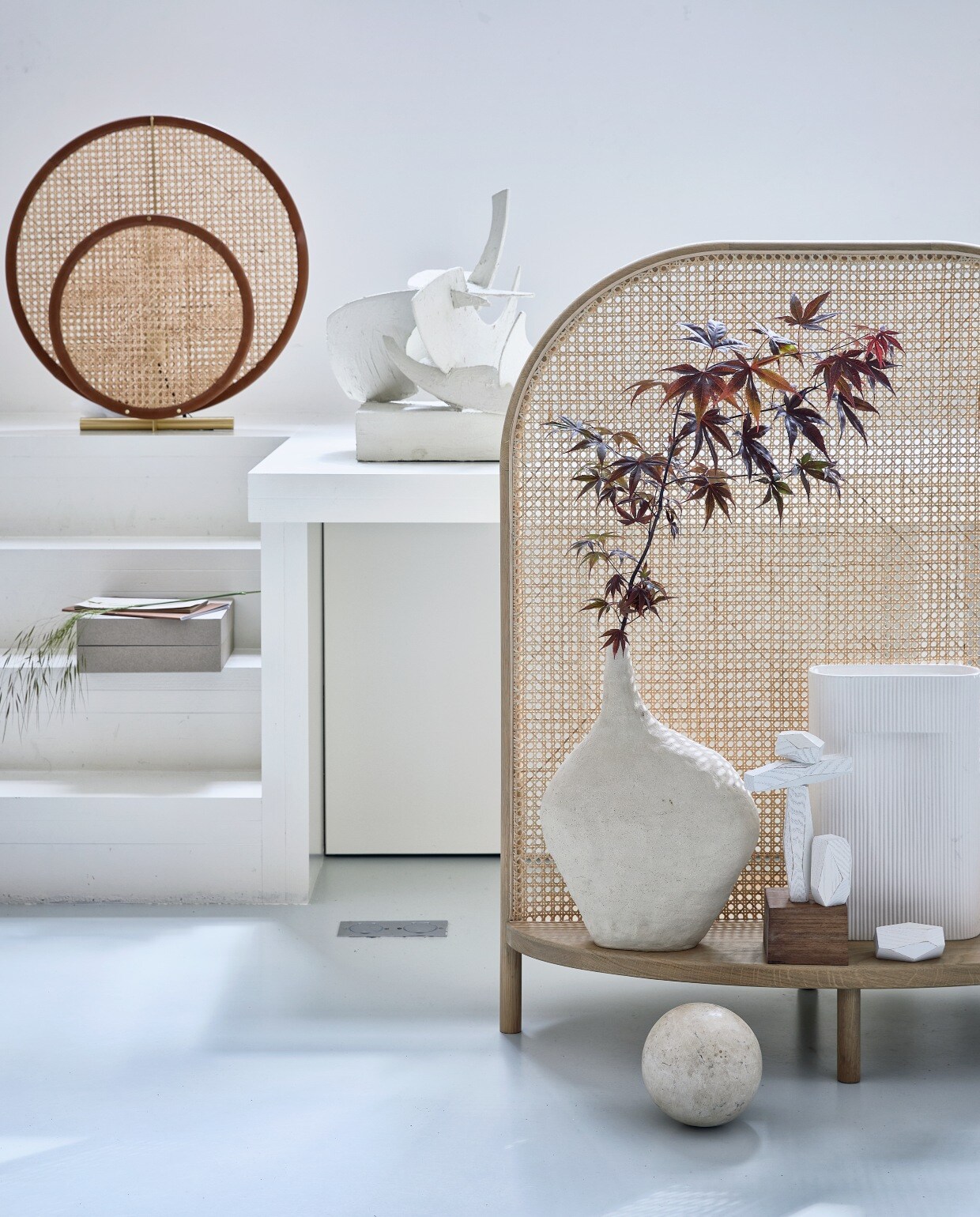 Geolied eikenhouten kamerschermFour, 110x90x45 cm (hxbxd) € 879,-(bolia.com). Ronde lamp AD van 101chp,Ø 60 cm € 700,- (melchiorinterieur.nl).Kunstwerk (tessaderijk.com).Handgemaakte vaas van Luna Mare€ 379,- (sukha.nl). Geribbelde vaas vanMuuto vanaf € 100,- (homestede.nl).Witte balancing blocks van FortStandard voor Areaware, per set € 65,-(vanons.eu).