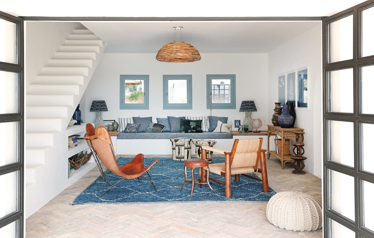 Inbouwbank met tafeltjes op maat gemaakt. Lampen gemaakt van ananasvazen. Krukken van geweven palmblad en vloerkleed Hubert Zandberg Interiors. De robuuste houten stoel is Mexicaans en vintage, net als de leren vlinderstoel.