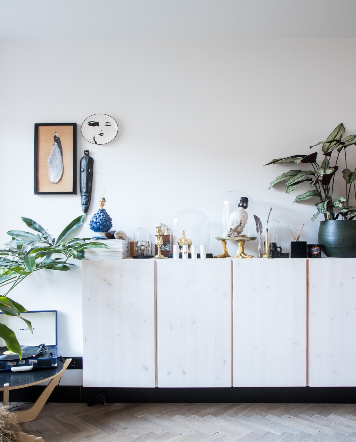 Kasten Ivar van Ikea, geschilderd in de kleur van de muur. Houten kruk en bijzettafel Arp Design. Vaasjes Tica. Staande lamp erfstuk. Herkomst vloerkleed en kussen onbekend.