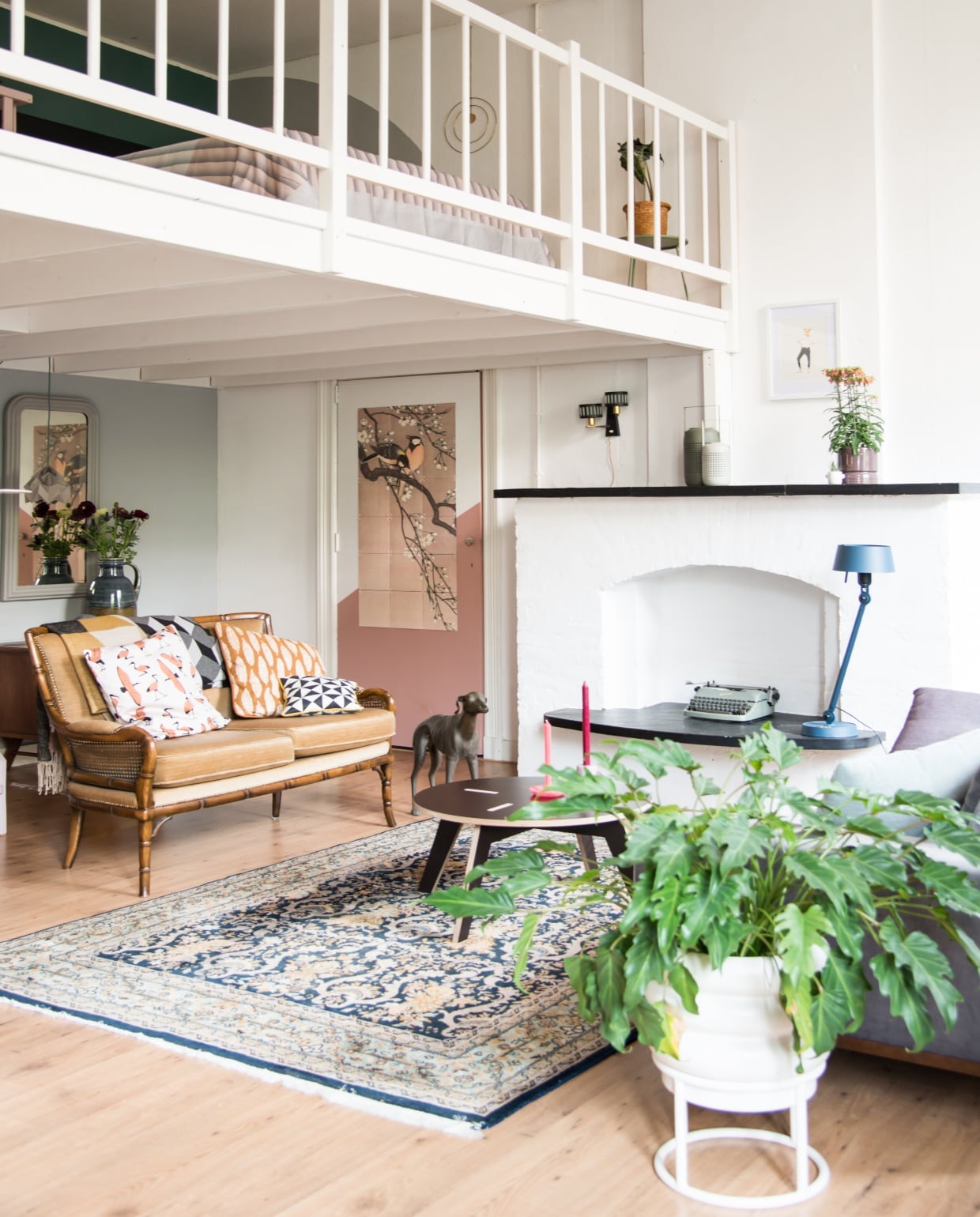 Bruine bank Marktplaats, fauteuil Libel van Artifort. Windhond tweedehands. Salontafel Fien van In Wood We Trust, kaarsenstandaards Bloomingville en Ontwerpduo. Tafellamp Tonone, illustratie boven schouw uit Portugal. Het vloerkleed is een familiestuk. Bank rechts Wehkamp, plaid Muuto.
