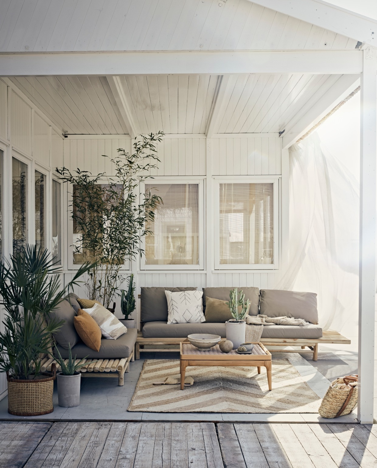 Buitenloungebank Twiggy van Applebee, 3-zits rechts € 725,-, 2-zits lounge-element links € 505,-, Twiggy lounge hoektafel € 309,-, afmeting set 329x261x70 cm (lxbxh) (fonteyn.nl). Juten vloerkleed van Madam Stoltz, 150×245 cm € 295,- , planten met pot van vtwonen vanaf € 25,90 (vtwonen.nl). Okergeel geruit kussen € 28,95, wit kussen met zwart borduursel € 53,-, grijs schaaltje € 11,-, kom € 6,95 (madamstoltz.dk). Rotan manden € 39,99, wit met beige kussenhoes € 19,99 (hm.com). Papier-maché schaal € 38,40 (nordal.eu). Linnen kussen in karamel en kaki, 60×40 cm, katoenen plaid € 23,95 (iblaursen.nl). Salontafel met gevlochten blad Lima van Gloster, 81x81x31cm (lxbxh) € 2400,- (dacks.nl). Overig privébezit.