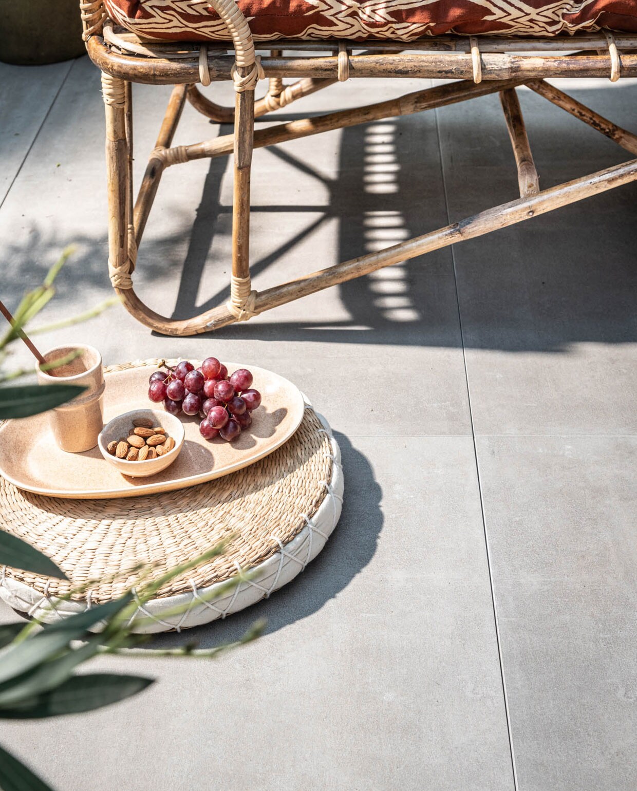 Buitentegels , 70x70x3,2 cm (lxbxh) per m² € 69,95.,  m.m.v. madamstoltz.dk (bamboe daybed, stoel, kussens, rond plat gevlochten kussen, servies, plaid), nordal.eu (ronde bijzettafel).