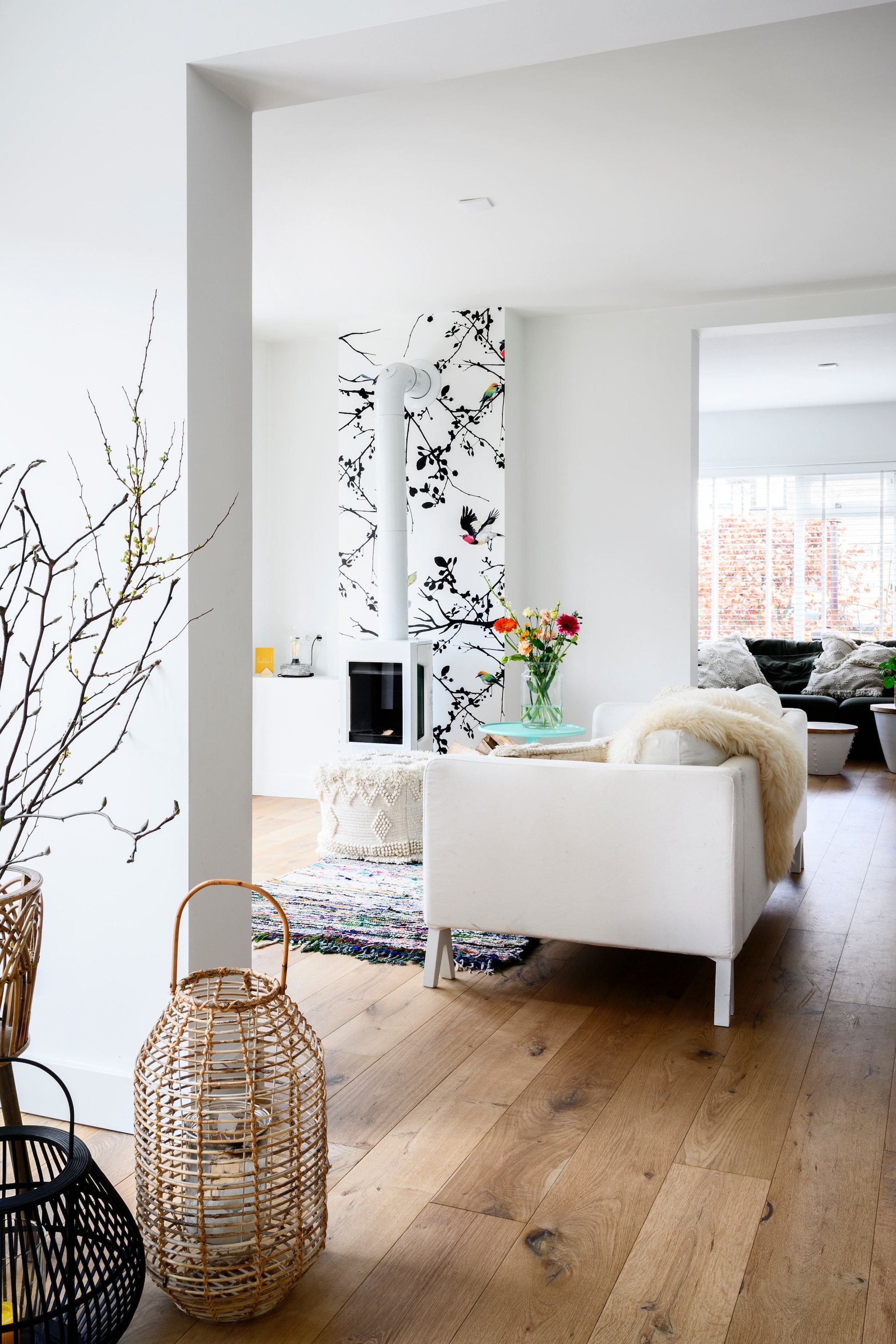 Bank Ikea, bijzettafel en vloerkleed Pols Potten, haard Jøtul via Pook haarden, mand Karwei, vogelbehang Etsy.
