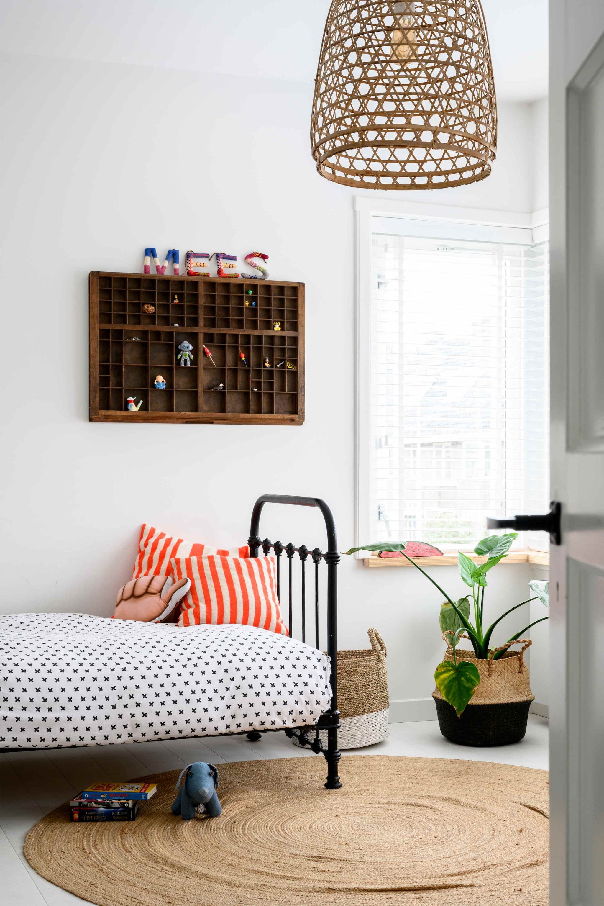 Zoon Mees verzamelt op zijn slaapkamer spullen in een oude letterbak. Kussen op bed uit Marokko, stoffen letters uit Frankrijk. Manden en vloerkleed Kwantum.
