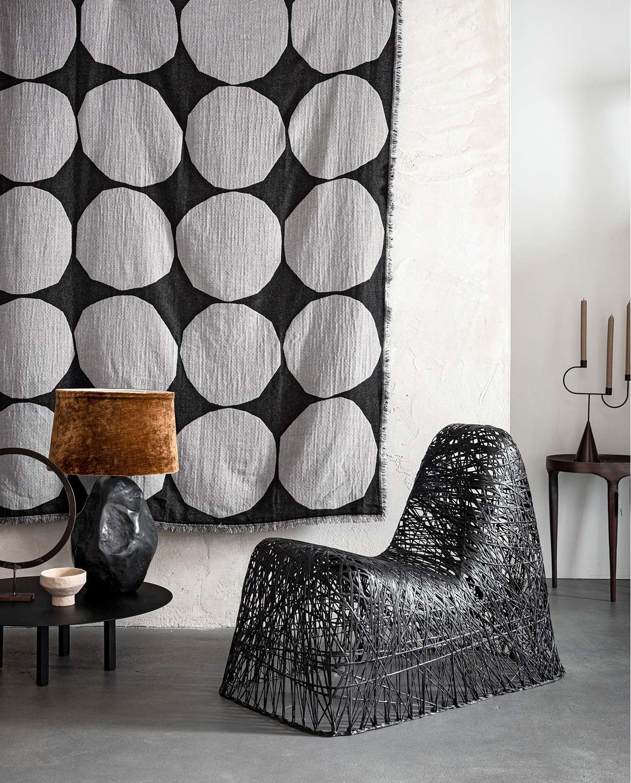 Wandkleed gemaakt van stof Kivet van Marimekko (coosdewitwonen), vergelijkbaar wandkleed van Marimekko, kandelaar (klevering.nl). Lage bijzettafel van Serax (vtwonen.nl). Cirkel-object (loods5.nl). Tafellamp van Vaughan (wva.nl). Lampenkap bekleed met stof Aldwych in kleur Amber van Zoffany (stylelibrary.com). Stoel, bijzettafel van bruin metaal (loods5.n/design). Overig privébezit.