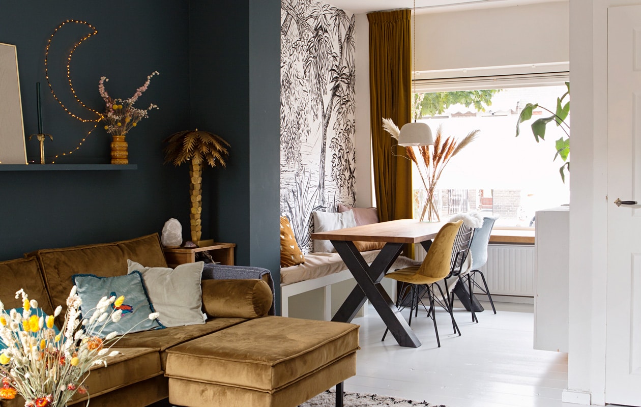 Bank Rodeo van Be Pure Home in honing geel, palmboom lamp hkliving, maanlamp zelfgemaakt (Luka verkoopt deze via haar ), tafelblad en -poot via Marktplaats, gele en blauwe velours stoelen Kick, zwarte metalen stoel vintage, hanglamp SissyBoy, wandplank Ikea, accessoires op wandplank vintage vondsten.
