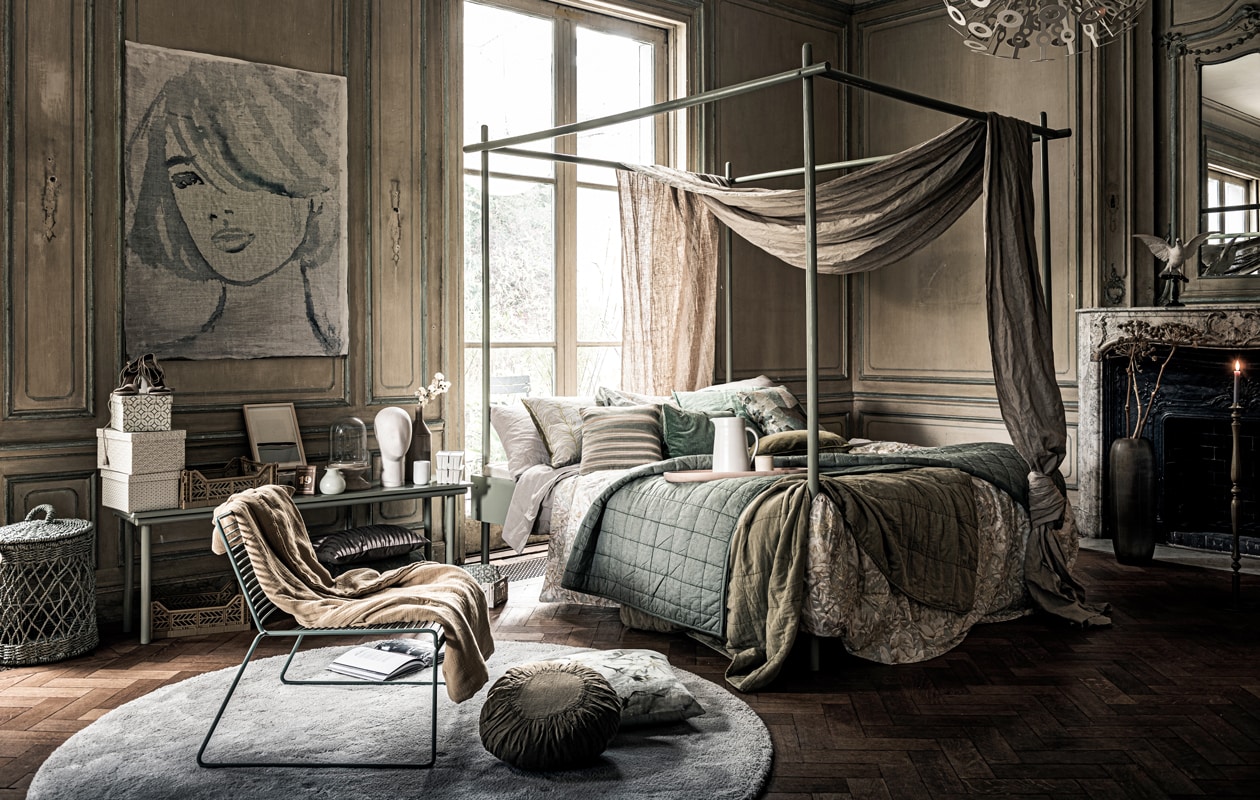 Schilderij vrouw, schilderij op bank (tinystories.nl). Bed met bankje (com-anders.nl). Groene stalen stoel (hay-amsterdam.com). Grijs rond kleed per m², houten dienblad op bed, vaas met takken naast haard, kussen op bed met streep (homestede.nl). Mand links, bruine vaas rechts op bankje met tak erin, mosterdgele kratten (loods5.nl). Beige hakken op doos, wit gezicht, grijs katoenen dekbedovertrek, boek (hm.com). Lichtgroen vaasje op bank, stolp (weldaad.com). Rond kussen op de grond Anais van Madam Stoltz (vtwonen.nl). Grijs kussen met dunne lijnen op de grond, groen kussen op bed links (wva.nl). Groen kussen op bed met print Geo Moderne Pewter van Designers Guild, 50×50 cm (designersguild.com). Groene plaid met stiksel, dekbedovertrek met print (zarahome.com). Mintgroen velours kussen op bed, mosterdgroen velours kussen, bruin kussen onder bankje, etui naast bed op de grond, doosjes, set van 3 (bungalow.dk). Gele mok op bed, witte doosjes rechts op bank, paperclips in doosje met 19 erop (letoile.store). Witte kan op bed (sukha.nl). Duif (taxidermy- amsterdam.nl). Mosterdkleurige staande kaarsvoet, mosterdkleurige plaid op bed (brechtmurreatelier.nl). Gele plaid op stoel (archive-store.nl). Overig privébezit.