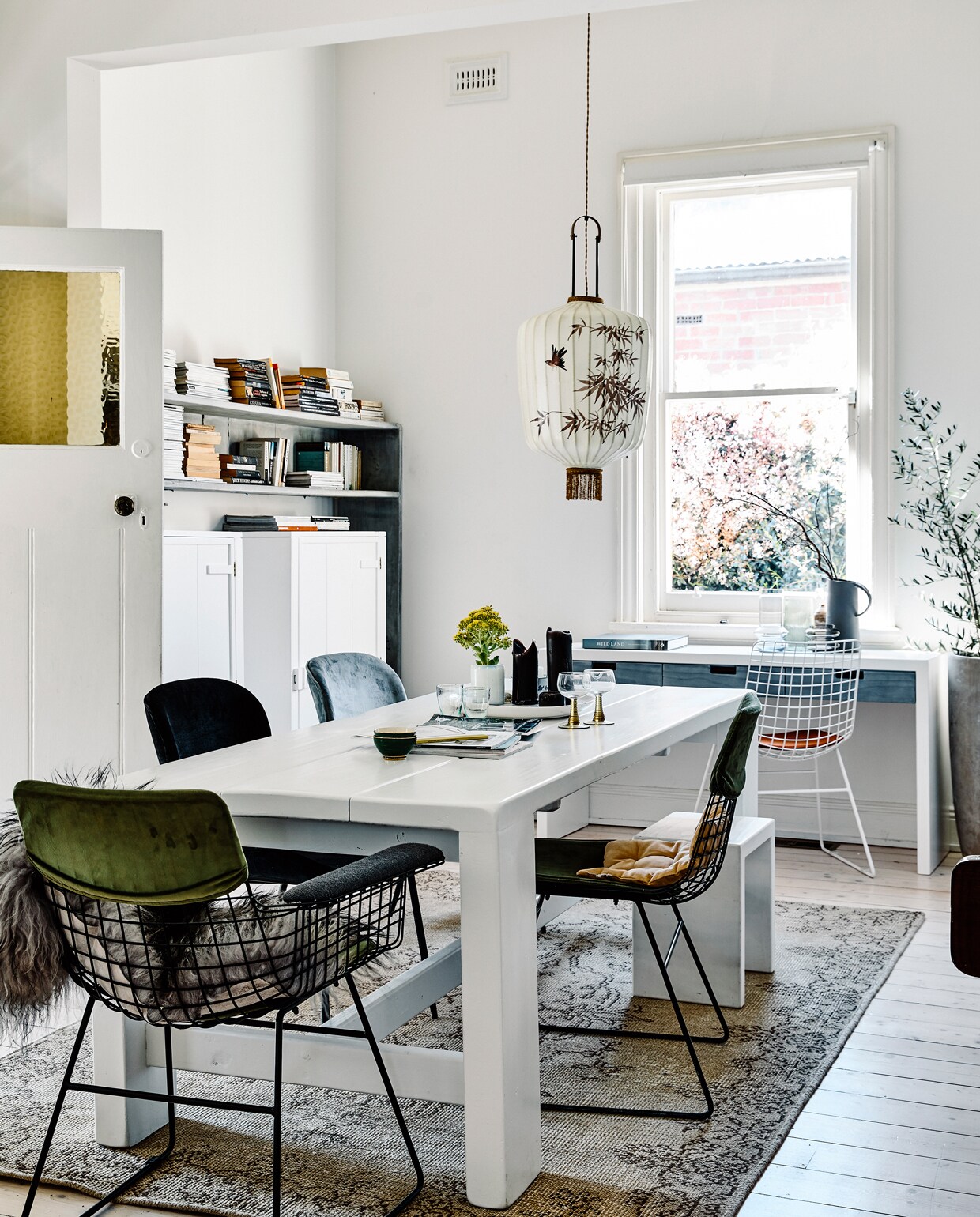 Kasten, tafel, bureau en kruk van House of Orange. Vloerkleed, stoelen en lantaarnlamp van HK Living. ‘De basis kreeg neutrale tinten – wit, lichtgrijs en houtskoolzwart –, de aardetinten van de accessoires maken het zwoel. Als ik groen kies, wordt het smokey green. Ga ik voor bruin, dan wordt het tabak. Wil ik geel, dan kom ik thuis met oker en bij goud met een messing tint. Alles een beetje sleets, dat geeft een mooi doorleefd karakter.’