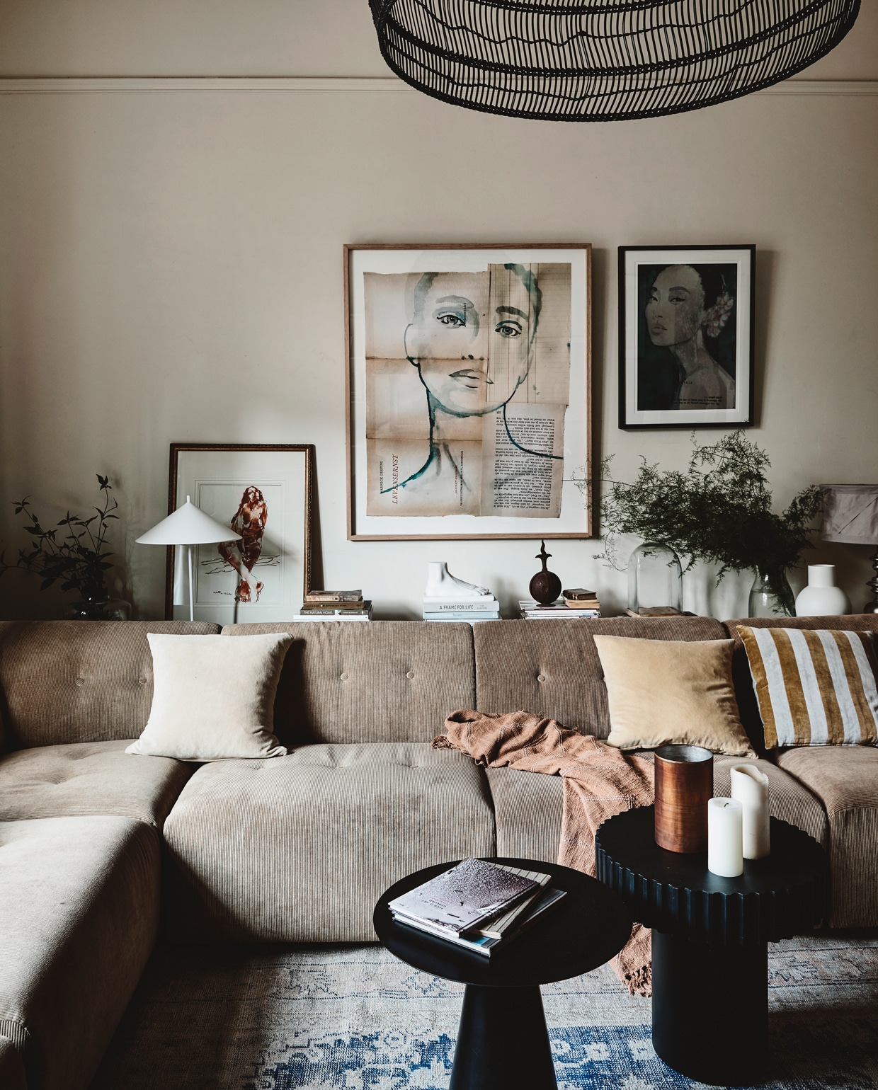 Vintage vloerkleed in Parijs gekocht. Bank, lampen, tafeltjes, plaid en gestreept kussen van HK Living. Overige kussens vintage. Spiegel House of Orange. Achter de bank staat werk van een onbekende Finse kunstenaar. Het grote werk aan de muur rechts is gemaakt door Tiny de Vries. ‘Van laagjes papier uit oude boeken.’