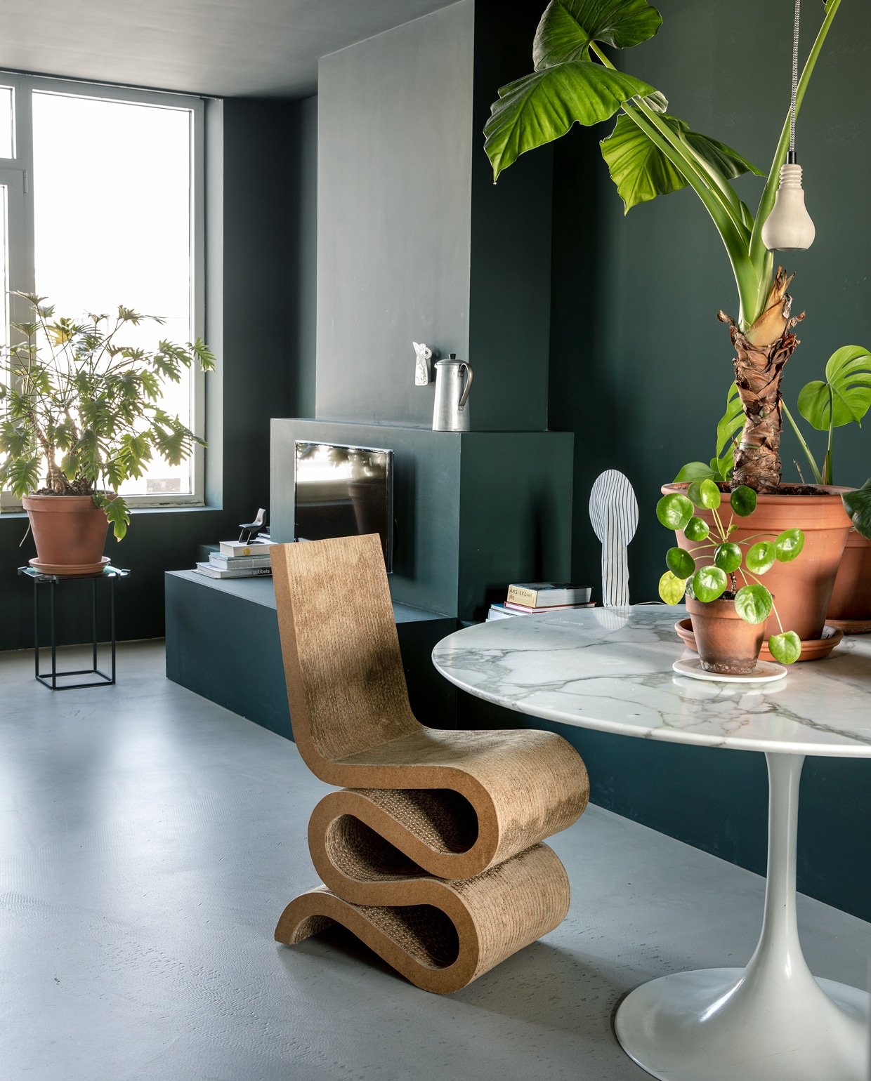 Vintage tafel Tulip van Eero Saarinen voor Knoll Studio. Planten en potten Intratuin. Betonnen hanglampen Edison van Tove Adman via Anno Design. Wiggle Side Chair van Frank Gehry is een erfstuk. Verfkleur RAL 6012 zwartgroen.
