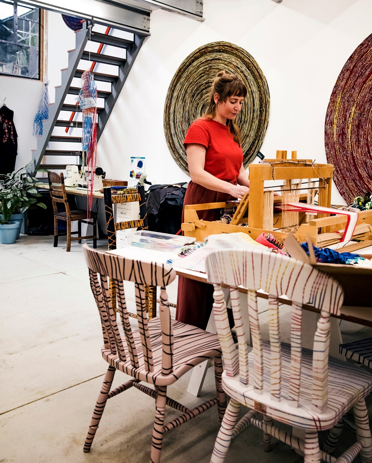 Bij het keukenblok staat een klein weefgetouw. ‘De plaids voor Return to Sender worden geweven op basis van lappen die ik daarop met de hand heb geweven. Op het weefgetouw kan ik zelf allemaal testen maken. Ik wil eerst zien hoe iets uitpakt voordat het door een fabrikant wordt vertaald naar een echt product.’