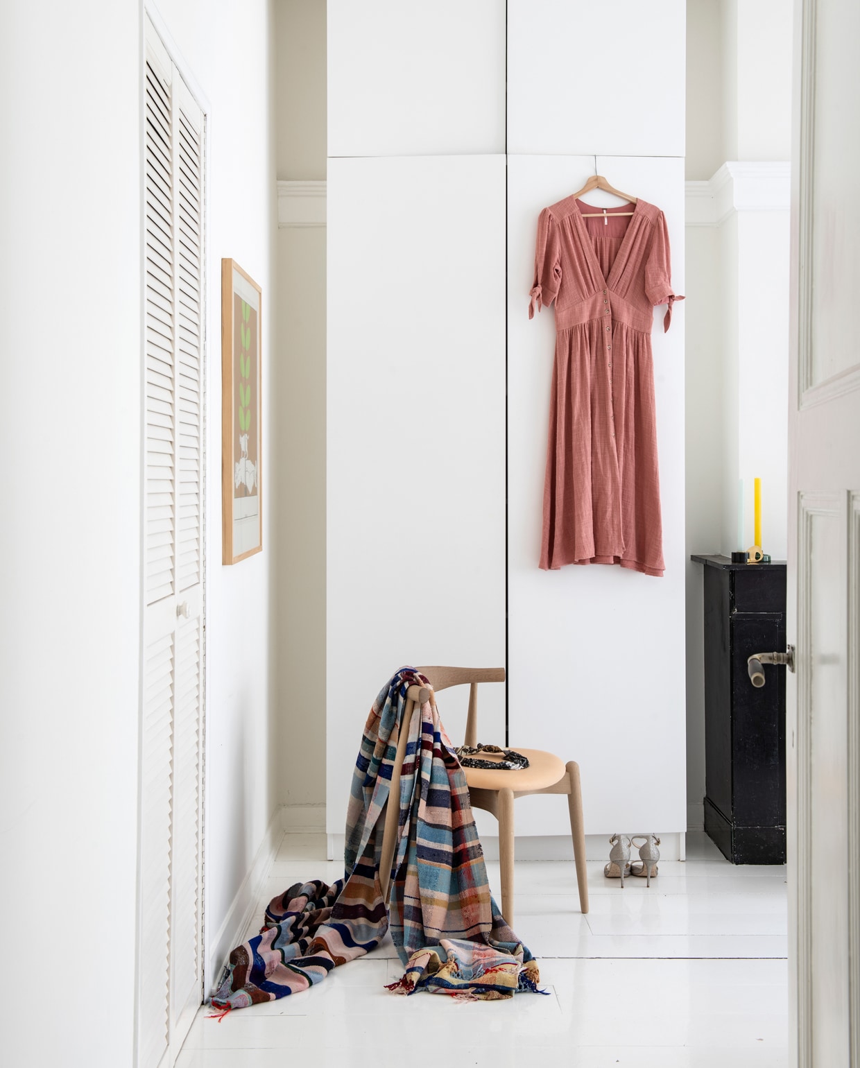 De slaapkamer van Anne Mei en Hans met een stoel en sprei van The Modern (modernvintage.nl). De plafondhoge kast zat al in het huis en staat vast aan de muur.