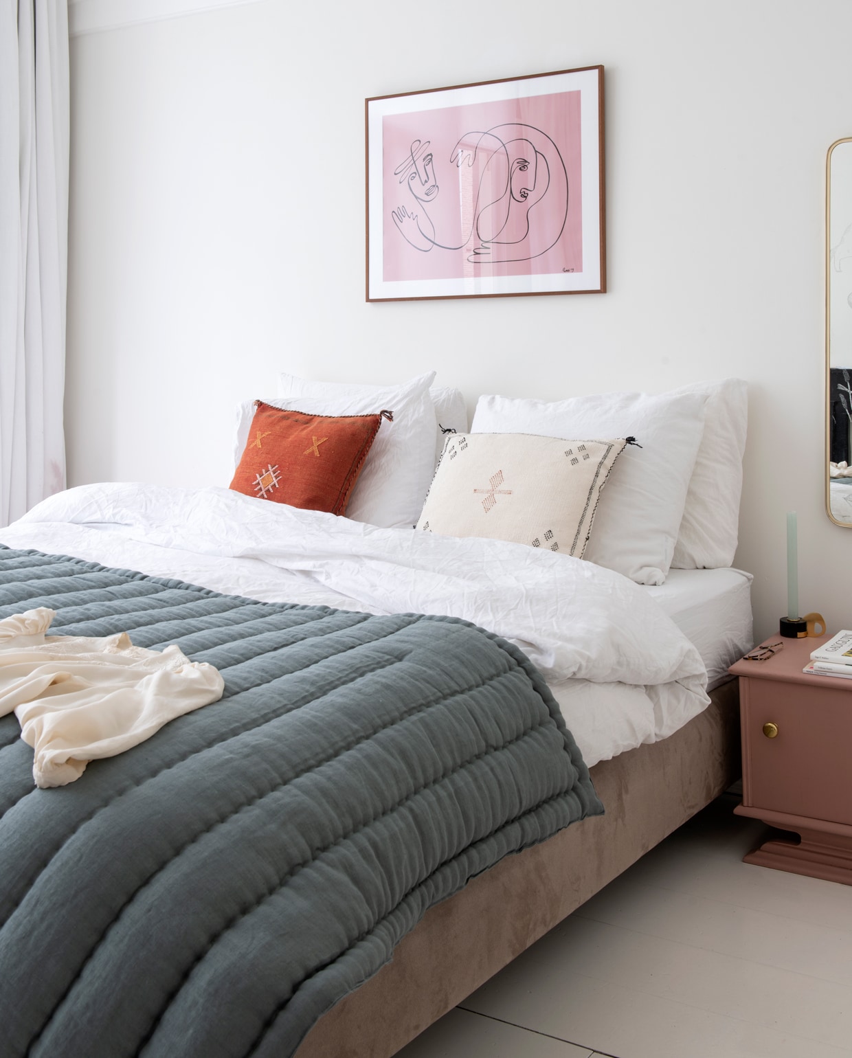 Het vintage roze kastje en de spiegel met tekeningen vond Anne Mei bij All the Luck in the World. Kandelaar van de rommelmarkt. Staalgrijze bedsprei van Archive Store, bedlinnen van The Modern. Het werk aan de muur heeft Anne Mei geschilderd.