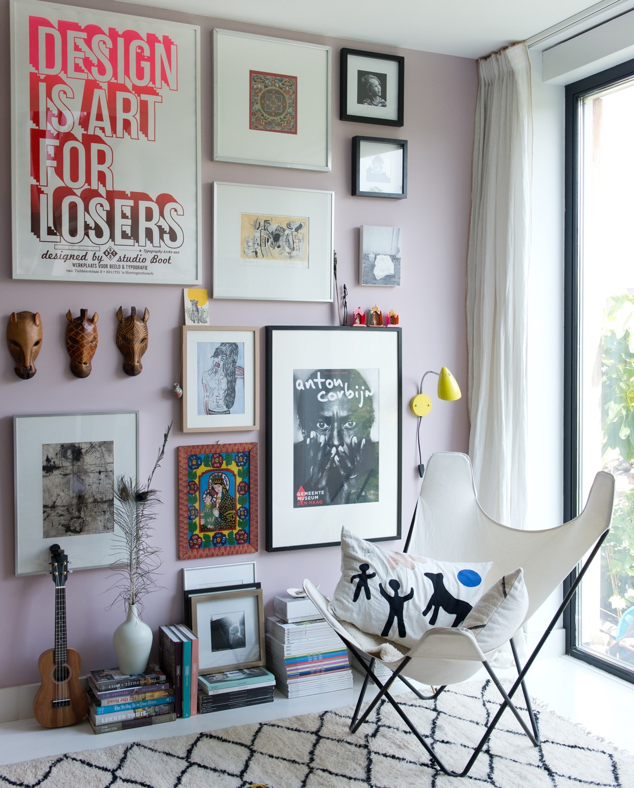 Kunst, posters en prints van o.a. Studio Boot, Ivonne van der Velden, Anton Corbijn, Frank Willems en Mark Rothko. Witte lamp Tolomeo van Artemide. Geel muurlampje Waterquest. Kleed uit Marokko. Vlinderstoel erfstuk. Kussen Neeltje Geurtsen. Roze verf Noa van Fairf.