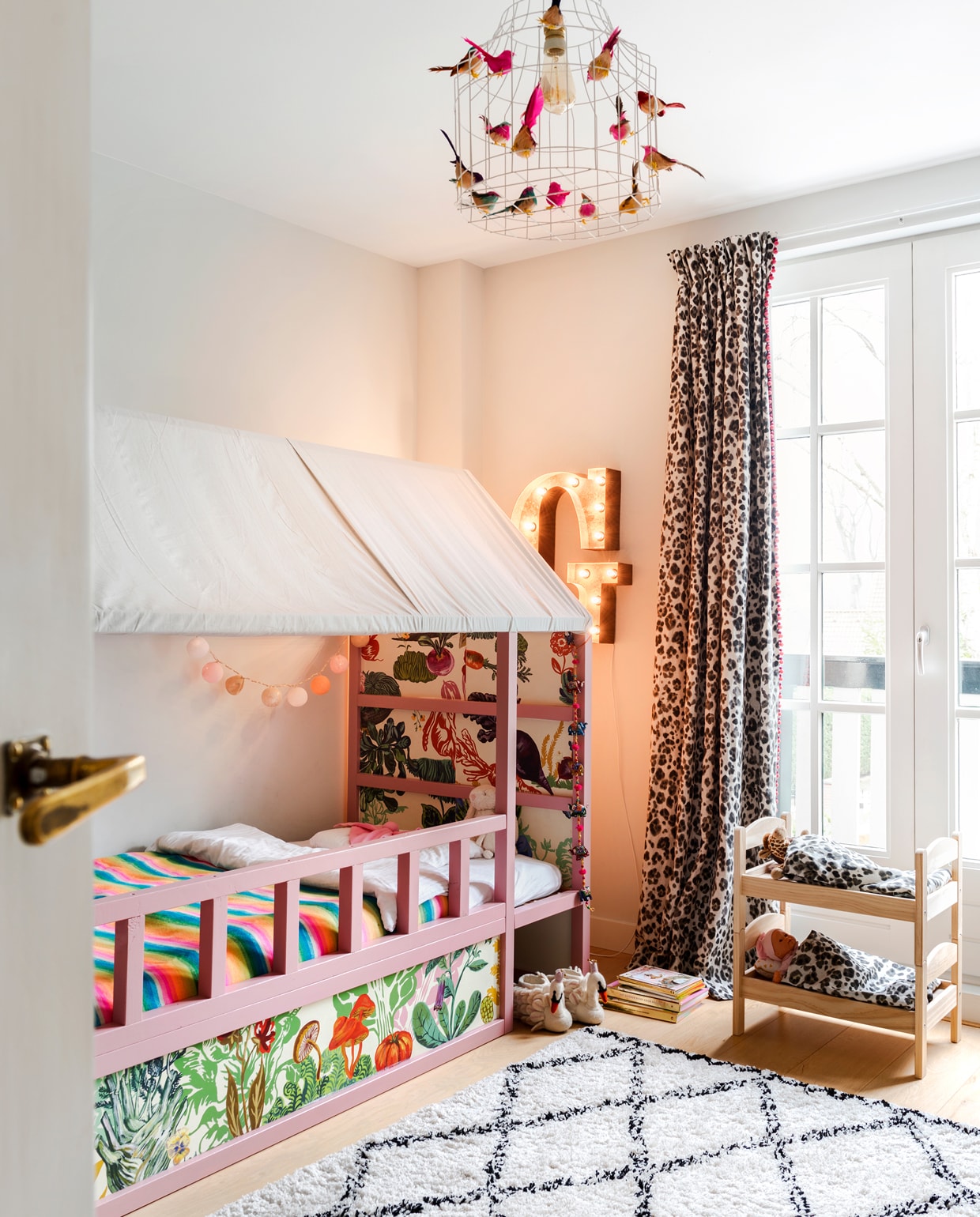 Sophie maakte het Ikea bed van Guusje uniek door er een dakje over te spannen en het te behangen en te verven. De letter G komt uit Amerika. Gordijn met dierenprint gemaakt van stof van Thibaut. Lamp Dutch Dilight.