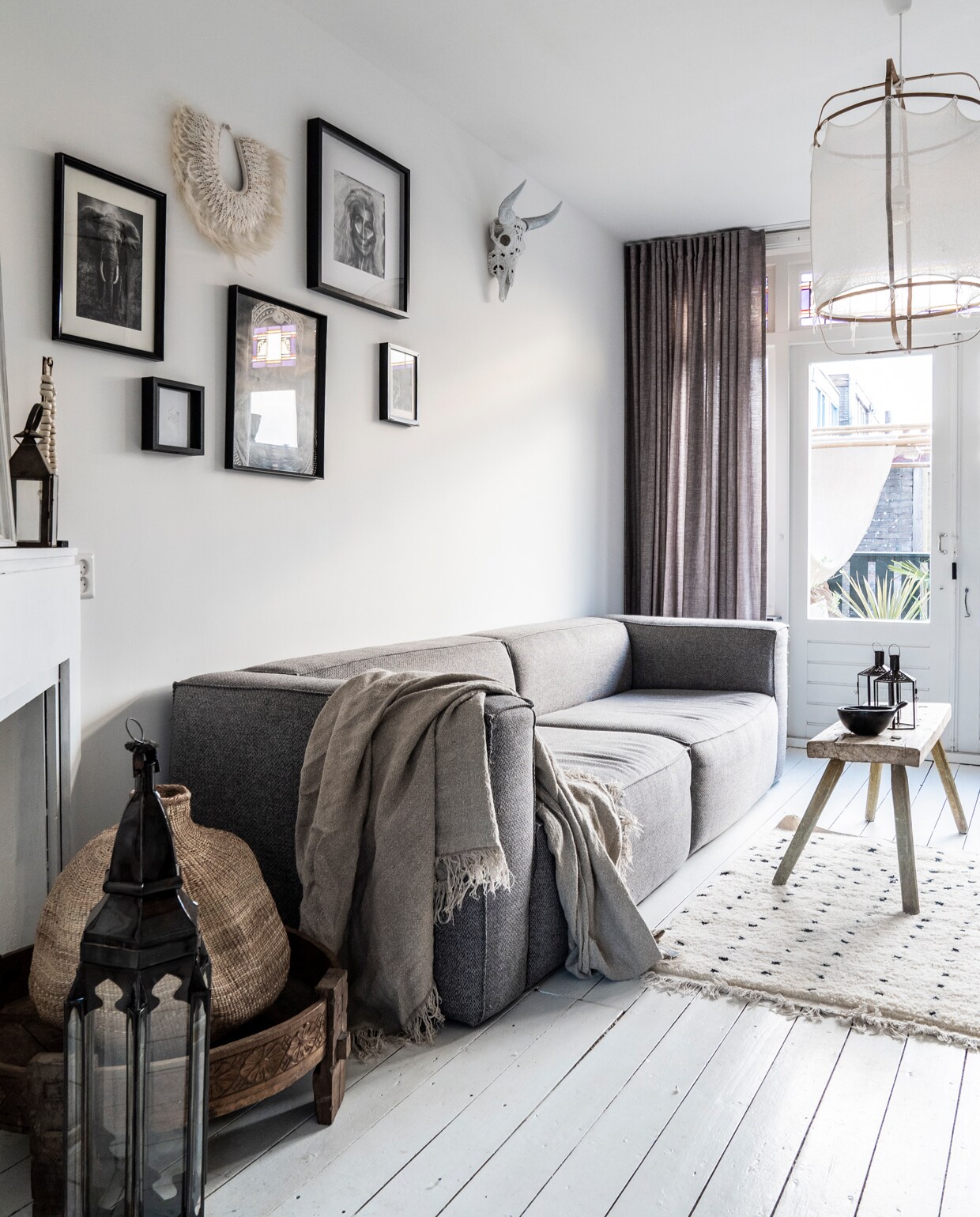 Bank Bean van Woood via Home Stock, grijze pot op voorgrond van Kwantum, gordijnen op maat van Inside Blinds, lamp gevonden via Instagram, houten bankje van natuurlijkast.nl, vloerkleed van benio.nl.