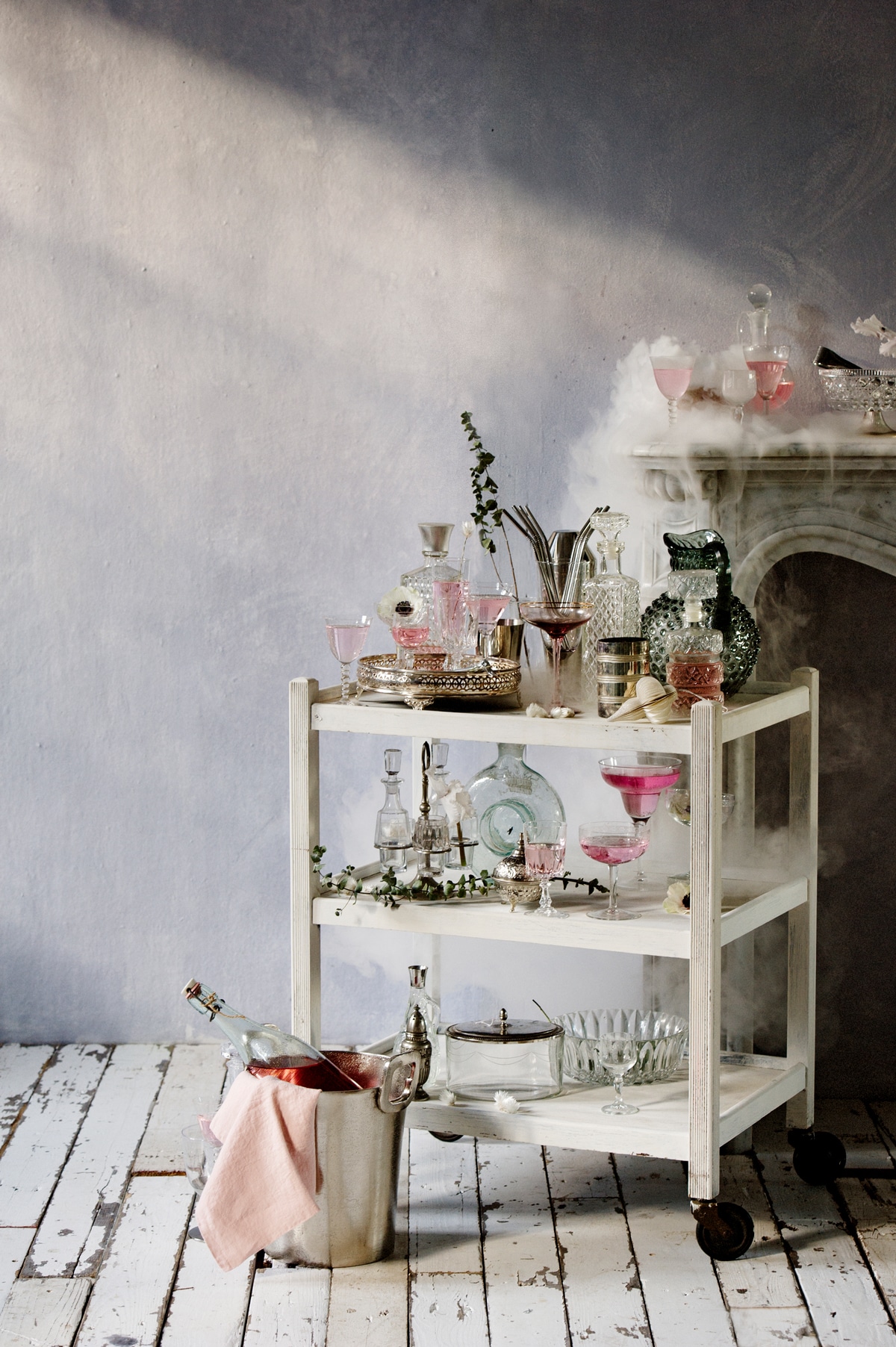 Muurverf lichtblauw kleur Iris, (bauwerk.com.au). Schouw van wit marmer (Jan van IJken). Bloemen en takken (judithslagter.nl). Witte trolley (Vroeger&amp;Toen). Wijnkoeler (PolsPotten). Ballen van karton, set van 2 (H&amp;M). Zilverkleurig dienblad (Zara). Zilverkleurige stalen rietjes (Dille&amp;Kamille). Lichtblauwe kan (Burbri Antiek). Karaffen, glazen trommel met zilverkleurige deksel, peper-en-zoutstelletje, klein zilverkleurig flesje (Vint Amersfoort). Blauwe glazen kan (artilleriet.se). Zilverkleurig glas (Maison NL). Limonaderecept van The Holy Kauw Company (theholykauw.nl) uit boek Limonade (Uitgeverij Snor). Glazen (kringloopwinkel). Roze servert privébezit.