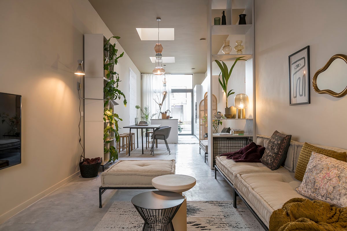 Roomdivider rechts – steengrijs (). Hanglamp (Fatboy), wandlamp (Zuiver), vakkenkast links – 3 stuks opgestapeld (vtwonen collectie), daybed (Household Hardware), tapijt (Kave Home), bijzettafel – zwart (Woood), bijzettafel – bruin (Nordal), poster (Bloomingville). Hondenbench en spiegel (privébezit).
