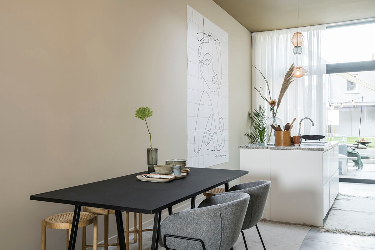 Glasgordijnen Malt in ecru (). Tafel (HAY), tapijt (HKliving), stoel (Zuiver), kruk (HKliving), hanglamp (Fatboy).