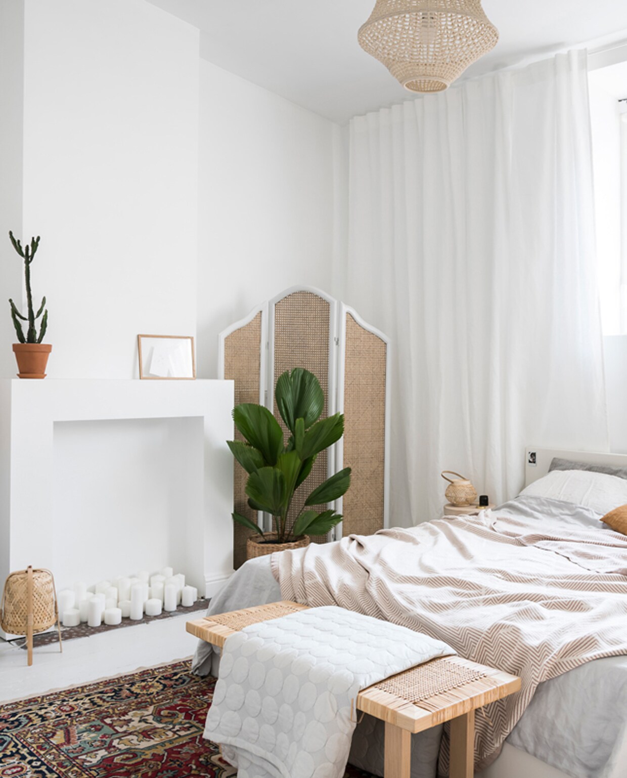 In de slaapkamer wilde Sofie een ‘LA-bohemian-holiday-at-home vibe’. Linnen lakens, gordijnen en plaids van H&amp;M Home. Het bed is van Ikea en aan het voeteinde staat een salontafel uit de Stockholm 2017 collectie van Ikea. Het kamerscherm is vintage. De houten kruk is van Fab, met daarop een lampje van Lucide.
