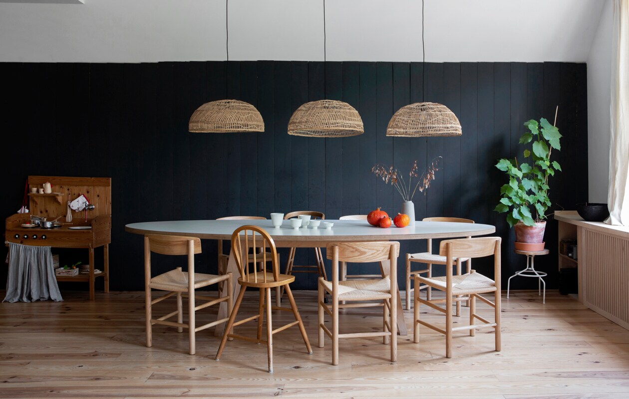 Muurverf Black Blue van Farrow &amp; Ball. Tafel ARP Design. Stoelen replica’s van Borge Mogensen’s J39 via Swivel UK. Kinderstoelen marktplaats.nl. Krukje Hema. Lampen HKliving. Schaaltjes, kopjes en vaasjes van Iittala, Broste Copenhagen, Annemieke Boots Ceramics, Søstrene Grene. Kommetjes links van Atelier Juliette Warmenhoven. Grenenhouten vloer, afgelakt met Skylt, via Wood and Stones.