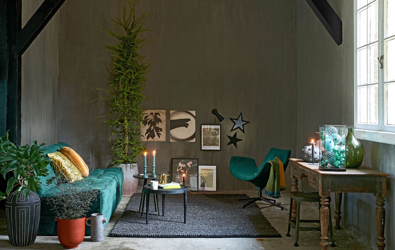 Zetel Cluster van vtwonen. Zwart tafeltje van Loods 5 Design, tafeltje met handvat van Loods 5 Design, fauteuil van Loods 5 Design, groen-gele sjaal, kussen rond, kussen vierkant (loods5.nl). Hoge vaas, zwart-wit grafisch, rode pot, kan, wandlampje, goudkleurige kandelaar cirkelvormig, zwarte vaas (housedoctor.dk). Zinken pot, antiek tafeltje, groene fles (weldaad.com). Tapijt Hjorthede, 170×240 cm, beeld, lijsten (ikea.be). Glazen stolp/vitrinekastje (hkliving.nl). Diverse groene kerstballen (rivieramaison.nl). Goudkleurige theepot (hkliving.nl). Sterren zelfgemaakt. Kruk, terracotta vaas en mok privébezit.