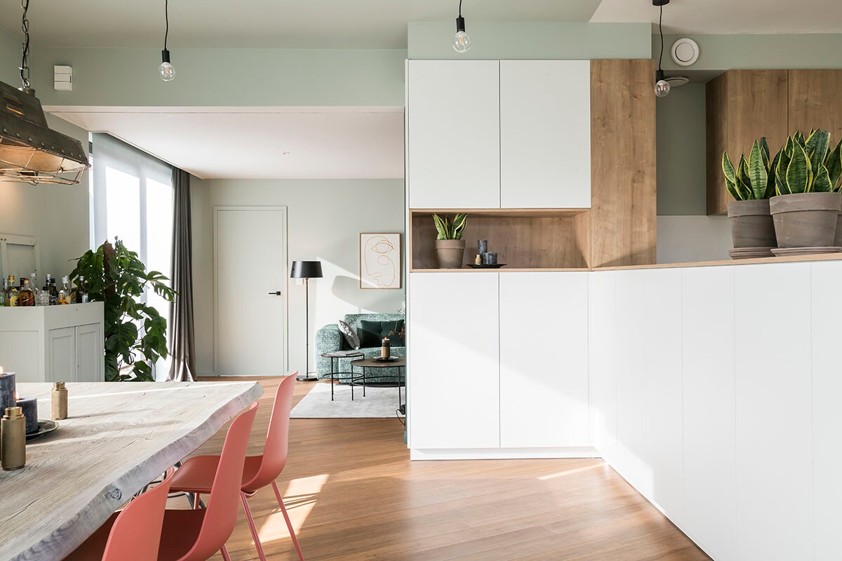 Hanglamp boven eettafel (BePureHome), eettafel (PMP Furniture), eetkamerstoel (Kave Home), vloerlamp (Woood), salontafel Elton (Lifestyle), poster (Paper Collective). Drankenkast (privébezit).