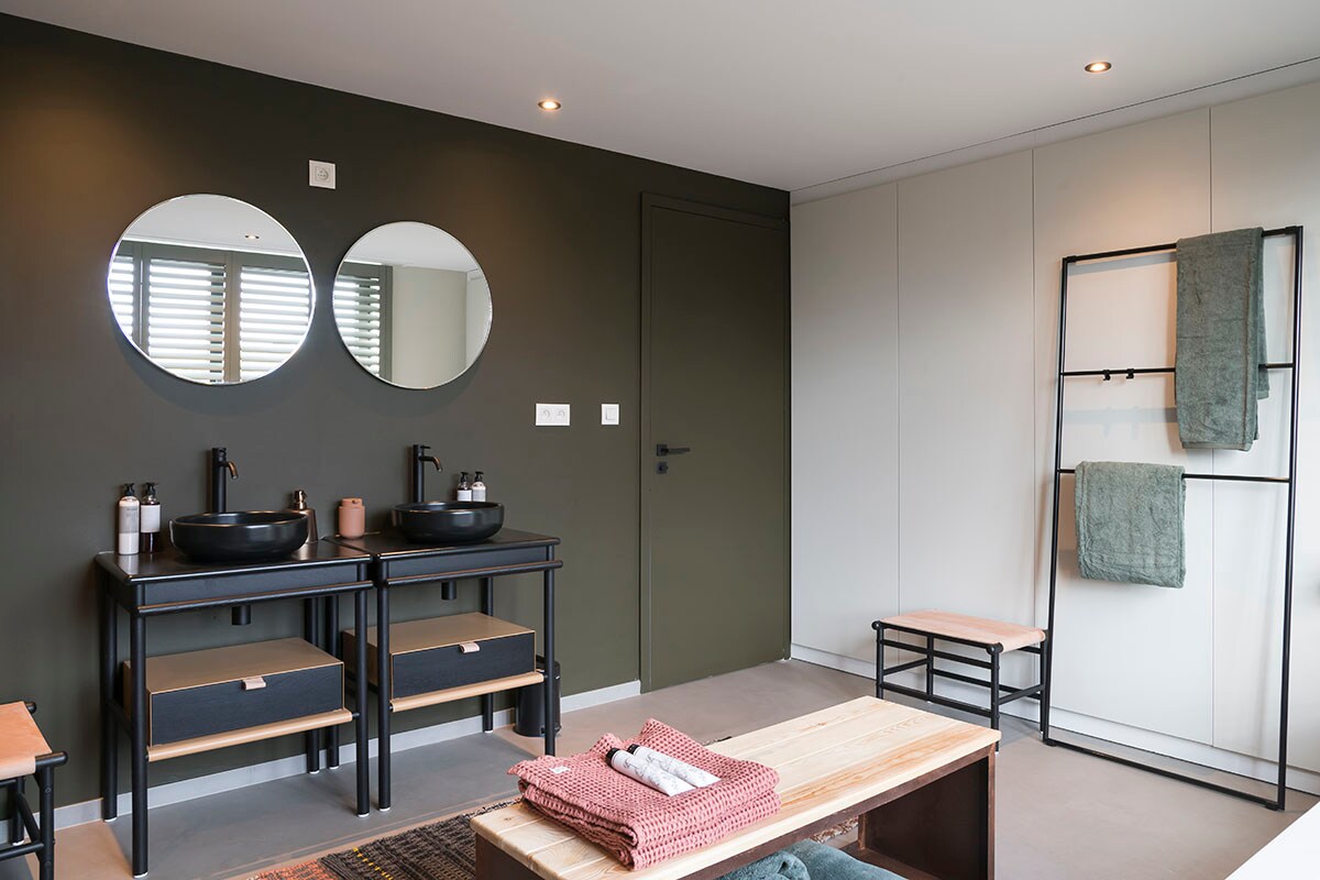 Zitbank (Redfire). Zitbankje, spiegel, wastafel, waskom, opbergbakjes onder wastafel: Mya – zwart/eik (Burgbad bij ). Handdoekhouder: Coco – zwart mat (Burgbad bij ). Wastafelkraan: Light – zwart mat (Paffoni bij ).