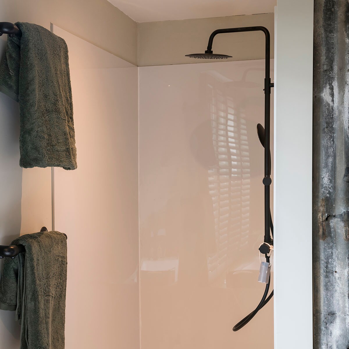 Kraanwerk douche: Nordica – zwart mat (Paffoni bij ). Douchebekleding: Panelle Eco – wit (Duscholux bij ). Handdoek – groen (Aquanova).
