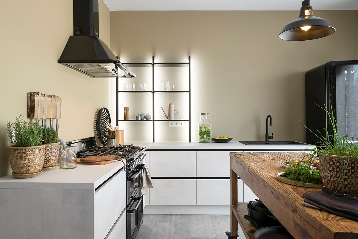 Keuken (). Dampkap, fornuis en vintage koelkast (SMEG bij ). Hanglamp (Lucide), tafel (Depot 59).
