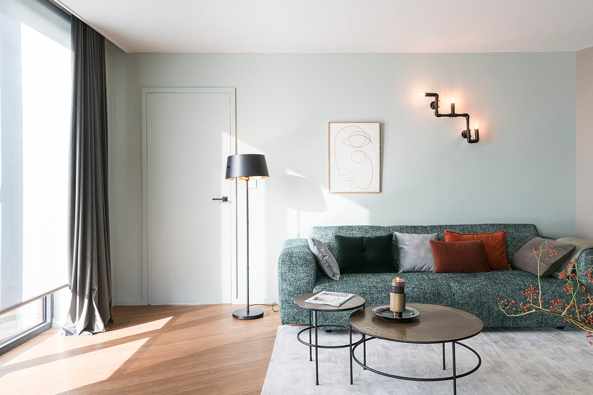 Rolgordijn Howland grijs (). Glasgordijn Velluto Vison (). Tapijt (Floorline), vloerlamp (Woood), salontafels Elton Coffee tables (Lifestyle), poster (Paper Collective).