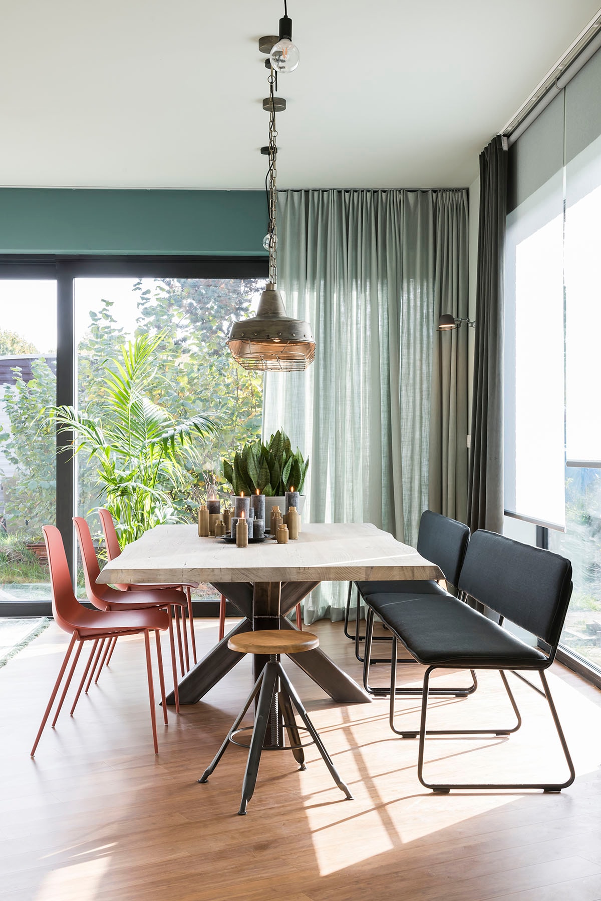 Rolgordijn Howland grijs (). Glasgordijn Velluto Vison (). Glasgordijn linnen mint (). Hanglamp (BePureHome), eettafel (PMP Furniture), eetkamerstoel (Kave Home), kruk (Woood), zitbank (Lifestyle).