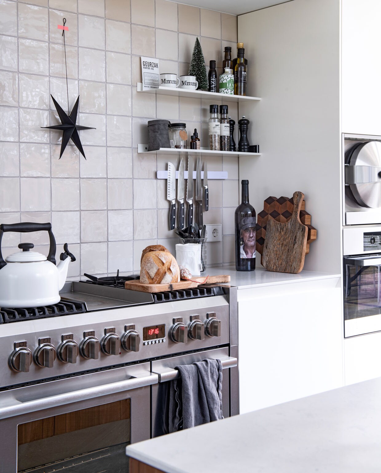 In ‘een knusse nis’ staat een fornuis van Bosch. Nieuwe witjes van Kwarts &amp; Co. Waterkoker Le Creuset, zwarte ster Stoer Metaal.